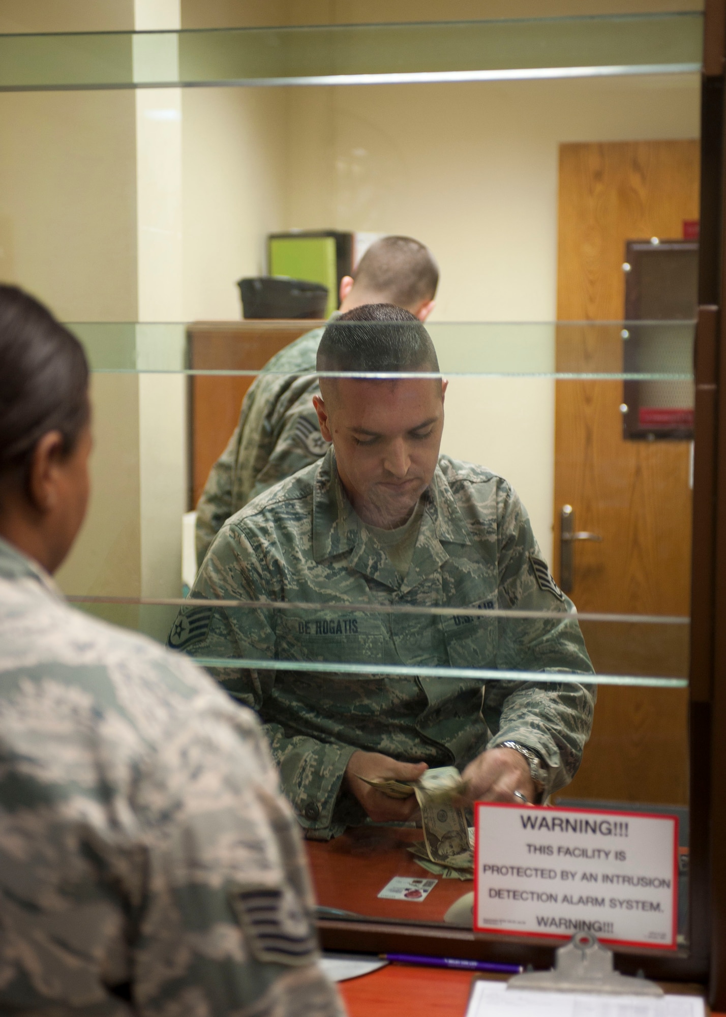 Staff Sgt. Clay DeRogatis, 39th Comptroller Squadron, counts money as he cashes a check for a customer Oct. 27, 2011, at Incirlik Air Base, Turkey. The cash cage on Incirlik is the only one on a U.S. Air Forces in Europe installation and offers base residents a place to cash checks. (U.S. Air Force photo by Senior Airman Clayton Lenhardt/Released)