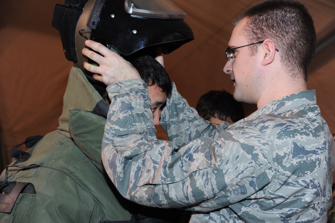 Airman 1st Class Eric Holm helps a Kyrgyz Republic soldier and fellow explosive ordnance disposal technician don a bomb suit during an information exchange at the Transit Center at Manas, Kyrgyzstan, Nov. 22. Holm is deployed to the 376th Expeditionary Civil Engineer Squadron from Mountain Home Air Force Base, Idaho. (U.S. Air Force photo/Tech. Sgt. Hank Hoegen)