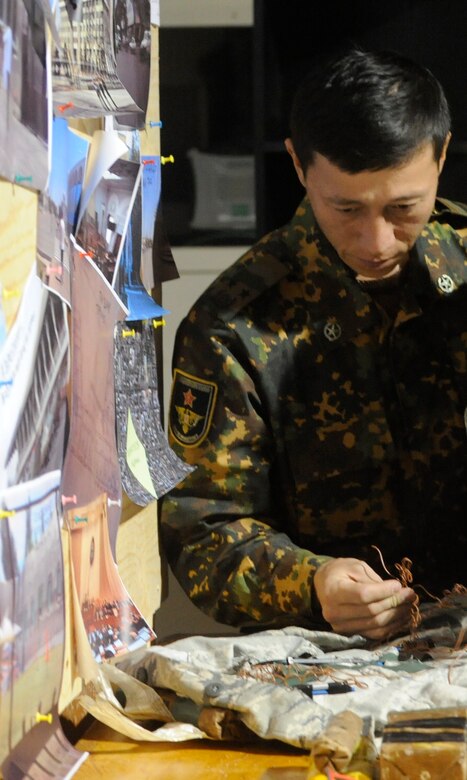 Kyrgyz Republic Lt. Col. Azamat Kurmanaliev examines an explosive ordnance display during an information exchange at the Transit Center at Manas, Kyrgyzstan, Nov. 22. Emergency responders from the Kyrgyz Ministries of Emergency Services, Interior and Defense participated in a joint explosive ordnance disposal and chemical, biological, radiological, nuclear and high-yield explosives response exercise here with their American counterparts. This exercise was part of a continuing partnership program. Kurmanaliev, who has an EOD background, is an MOD senior civil engineer. (U.S. Air Force photo/Tech. Sgt. Tammie Moore)