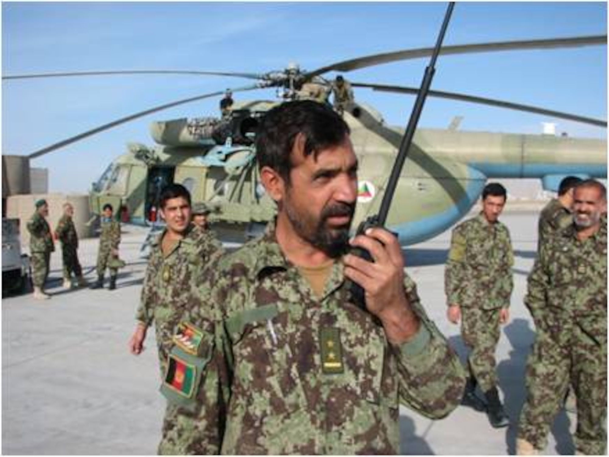 An Afghan Air Force expediter uses a radio to coordinate maintenance and pass status updates to the maintenance operations center. Maintenance advisers recently certified the first Afghan Air Force flight line expediter at Kandahar Air Wing. (U.S. Air Force courtesy photo) 

