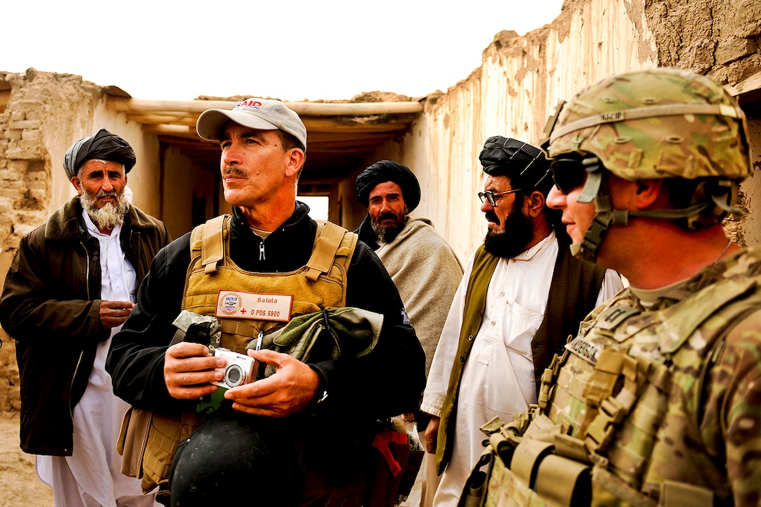 John Salata, center, and U.S. Army Capt. Michael Anderson, right, discuss a recent insurgent attack on a school in the Shah Joy disctrict in Afghanistan's Zabul province, Nov. 22, 2011. Salata is a field program officer with the U.S. Agency of International Development, and Anderson is a civil affairs member assigned to Provincial Reconstruction Team Zabul. The team's mission is to conduct civil-military operations in Zabul province to extend the reach and legitimacy of the Afghan government.