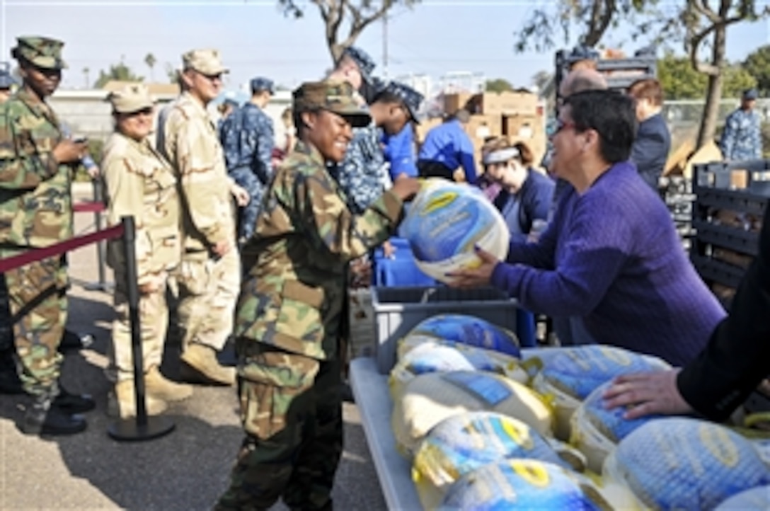 U.S. Navy Petty Officer 3rd Class Nannette Cordell receives her Thanksgiving turkey from the vendors of the Navy Commissary in Imperial Beach, Calif., Nov. 17, 2011. This year, about 300 active duty military members stationed at Naval Base Coronado received free gift baskets. Cordell is a hull technician.