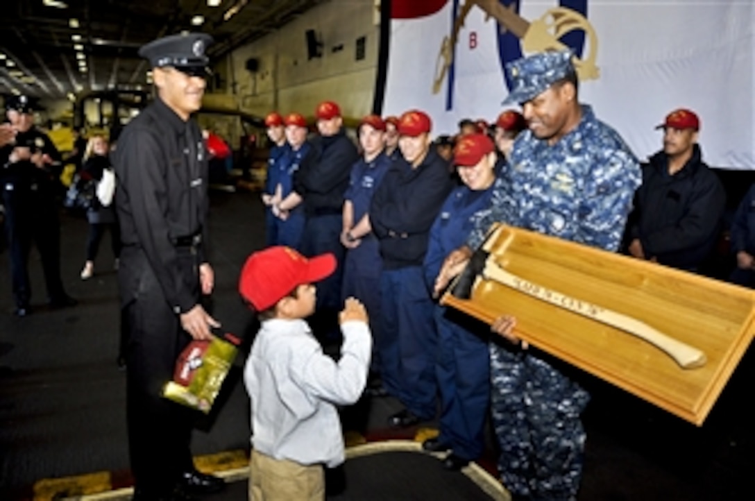 U.S. sailors assigned to the Ronald Reagan exchange gifts with firefighters from Los Angeles Fire Station 76 during their visit to the ship in San Diego, Nov. 21, 2011. The Ronald Reagan is at homeport in San Diego.