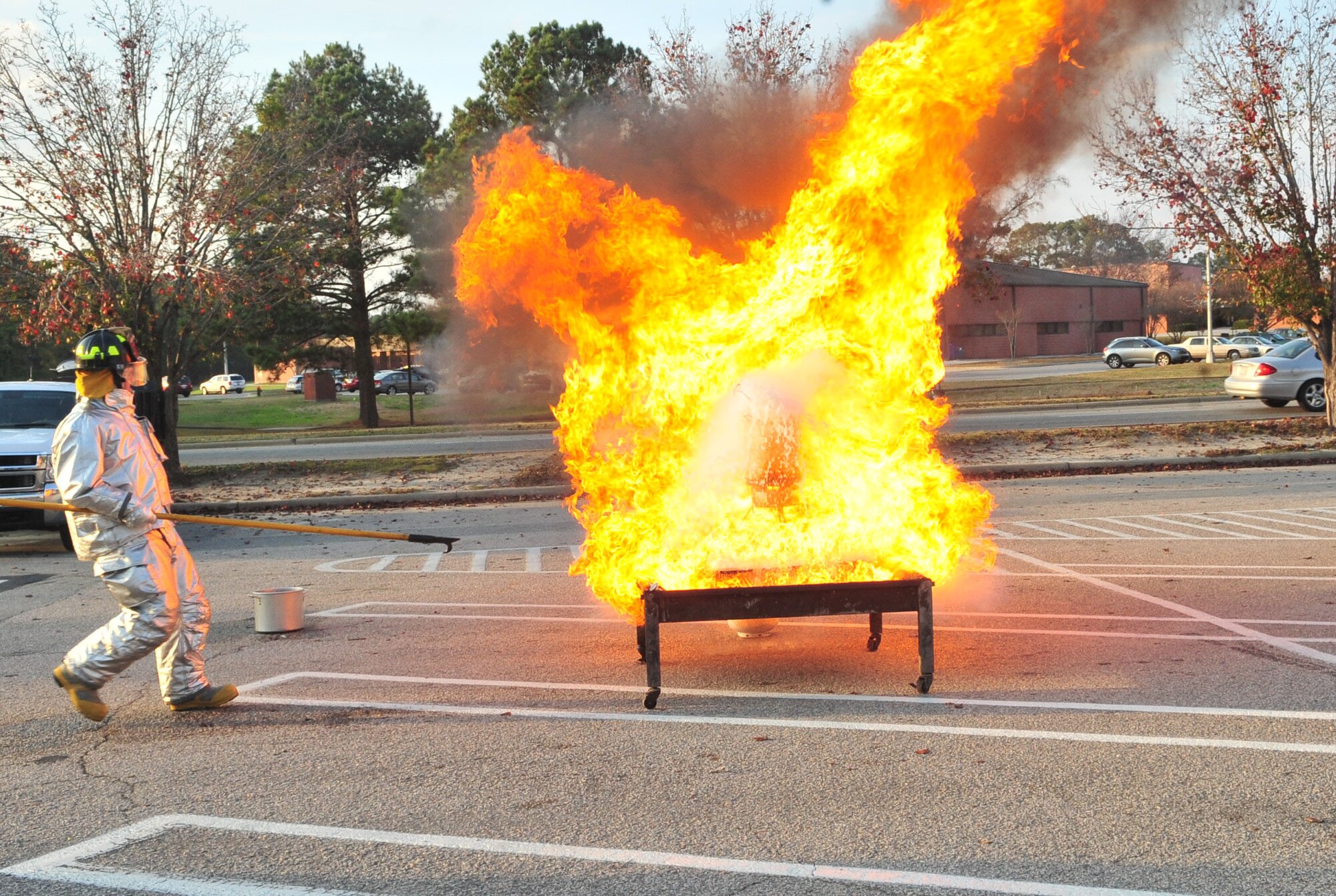 Airman 1st Class Daniel Morgan quickly backs away from a grease fire during the Turkey Fryer Fire demonstration at Seymour Johnson Air Force Base, N.C., Nov. 22, 2011. In less than five seconds, flames completely engulfed the pot and the supporting structure, representing the severity of what can happen when someone attempts to fry a turkey that has not been properly unthawed. Morgan, a driver operator with the 4th Civil Engineer Squadron fire services flight, hails from Idahla Falls, Idaho. (U.S. Air Force photo by Senior Airman Marissa Tucker)