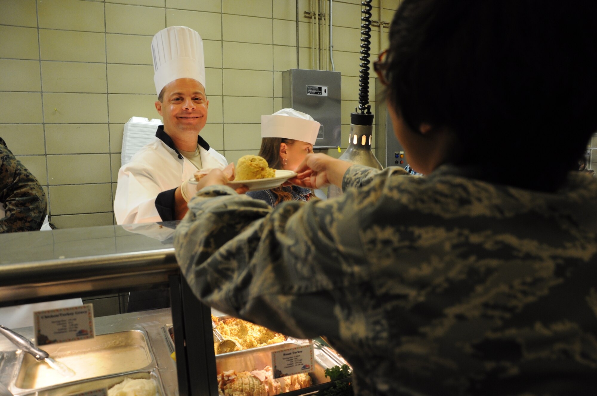 GOODFELLOW AFB, Texas -- Col. Mark T. Damiano, 17th Training Wing Commander serves an Airman during Thanksgiving luncheon at the Western Winds Dining Facility Nov. 24. Base leadership and spouses served and greeted hundreds of servicemembers and retirees as they entered the dining facility. 