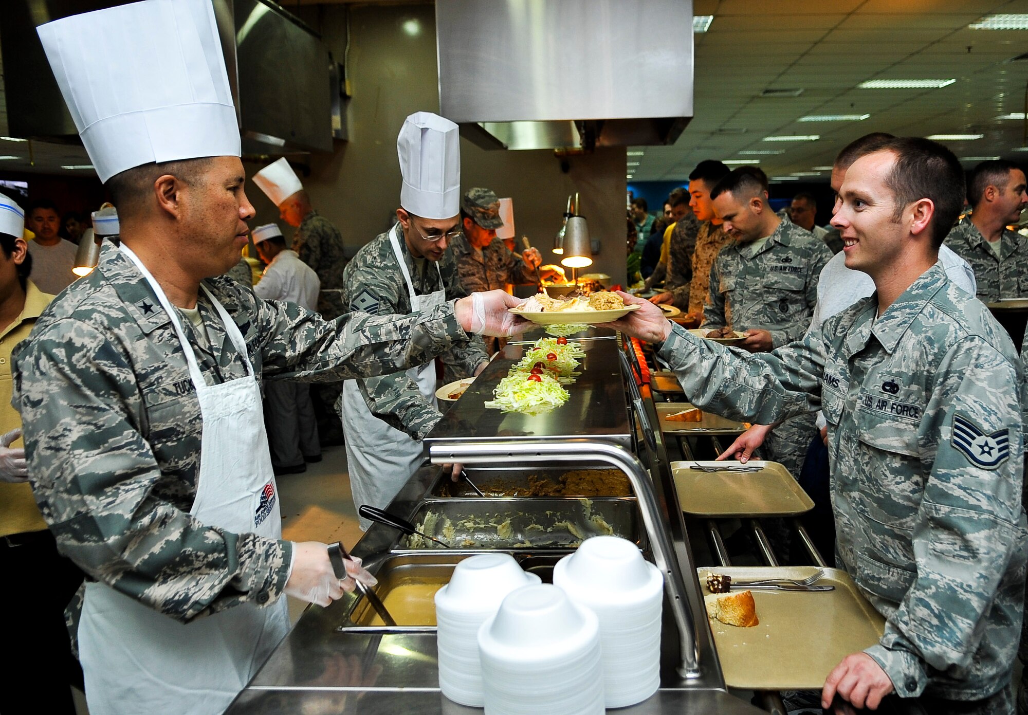 Brig. Gen. Giovanni Tuck, 379th Air Expeditionary Wing commander, serves Staff Sgt. Jake Williams, 340th Expeditionary Aircraft Maintenance Unit electrical and environmental specialist, Thanksgiving dinner Nov. 24, 2011, at an undisclosed location in Southwest Asia. Williams, a native of Dove Creek, Colo., is deployed from McConnell Air Force Base, Kan. (U.S. Air Force photo/Senior Airman Paul Labbe)
