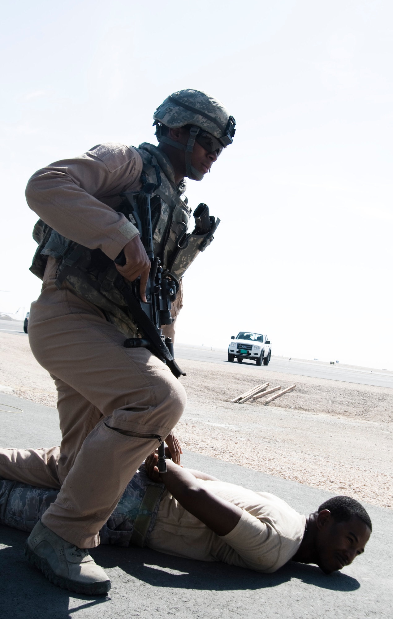 Airman 1st Class Daren Douglas Jr., 379th Expeditionary Security Forces Squadron Fly Away Security Team member, pins down an Airmen posing as a potential threat to an aircraft during training Nov. 17, 2011, at an undisclosed location in Southwest Asia. Douglas, a native of Fort Walton Beach, Fla., is deployed from Hill Air Force Base, Utah. (U.S. Air Force photo/Senior Airman Eric Summers Jr.) 