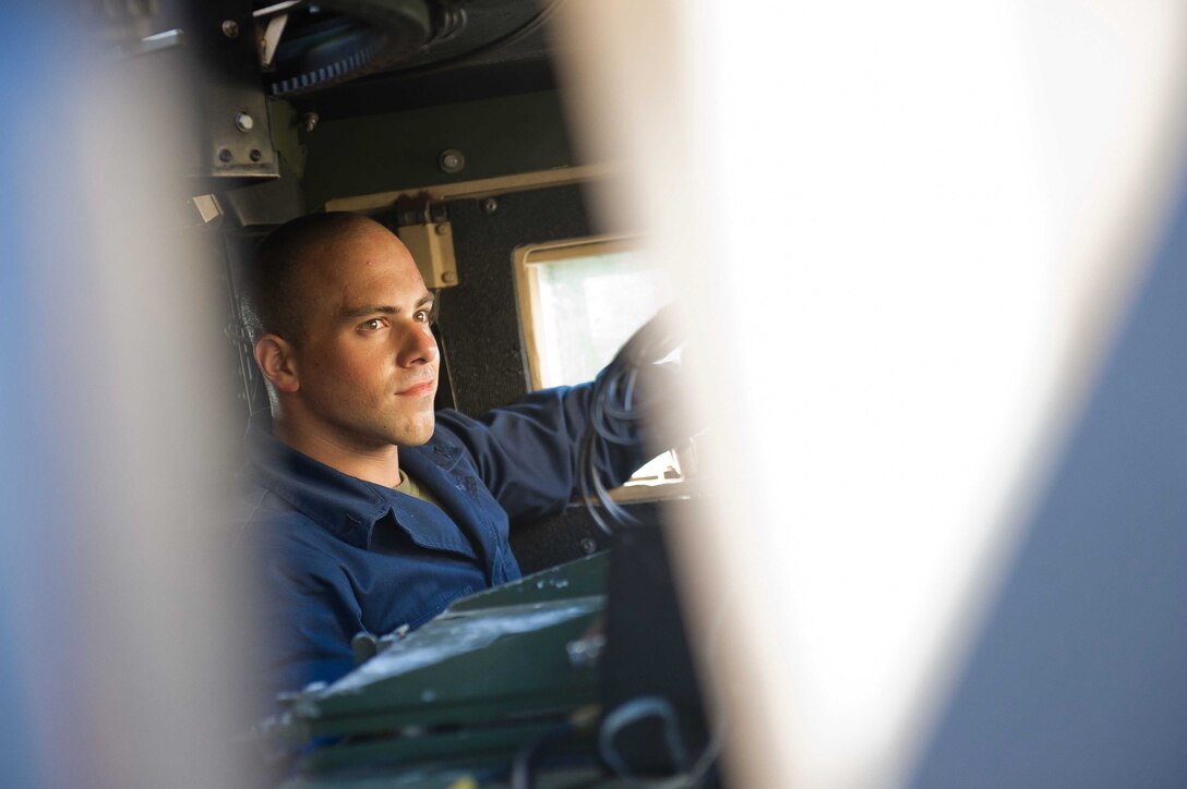 Lance Cpl. Aharon Y. Dahan starts up a humvee aboard USS Pearl Harbor to relocate the vehicle here Nov. 25. A Brooklyn, N.Y., native, Dahan is 24 and serves with the USS Pearl Harbor's combat cargo detachment.
