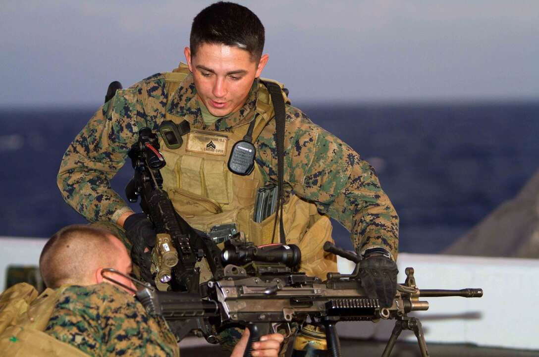 Team leader Cpl. Gerrick J. Watkins instructs a Marine on machine-gun procedures on the flight deck of the amphibious transport dock New Orleans here Nov. 25 during weapon drills with the 11th Marine Expeditionary Unit. Watkins is a 21-year-old Carrollton, Texas, native and serves with Company L.  The Pendleton-based company is one of three rifle companies with Battalion Landing Team 3/1, which is the ground combat element for the unit. The unit embarked USS Makin Island, USS New Orleans and USS Pearl Harbor in San Diego Nov. 14 beginning a seven-month deployment to the Western Pacific and Middle East regions.