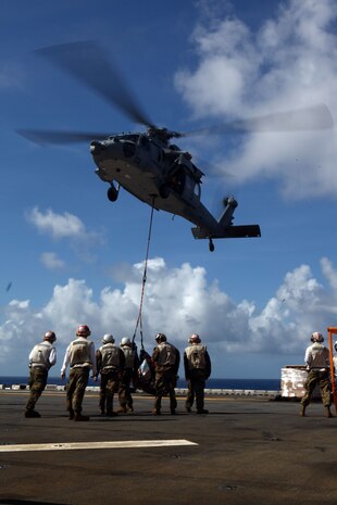 Marines with the 31st Marine Expeditionary Unit prepare to detach cargo as it is dropped by a MH-60S helicopter of Amphibious Squadron 11, Nov. 26. The Marines and Sailors were working together to move cargo aboard the USS Essex (LHD 2), during a vertical replenishment at sea. The 31st MEU is the only continuously forward-deployed MEU and remains the nation’s force in readiness in the Asia-Pacific region.