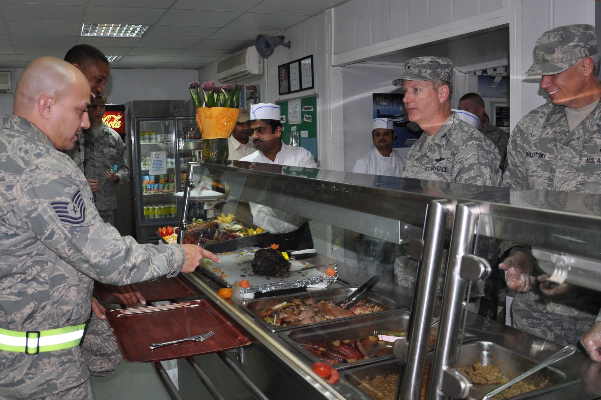 386TH Air Expeditionary Wing Commander, Colonel Michael Zick, and 386th AEW Command Chief, Chief Master Sgt. Mitchell Balutski, serve Airmen a traditional Thanksgiving meal Nov. 24 at an undisclosed location in Southwest Asia (U.S. Air Force photo by Senior Airman Rachelle Elsea)