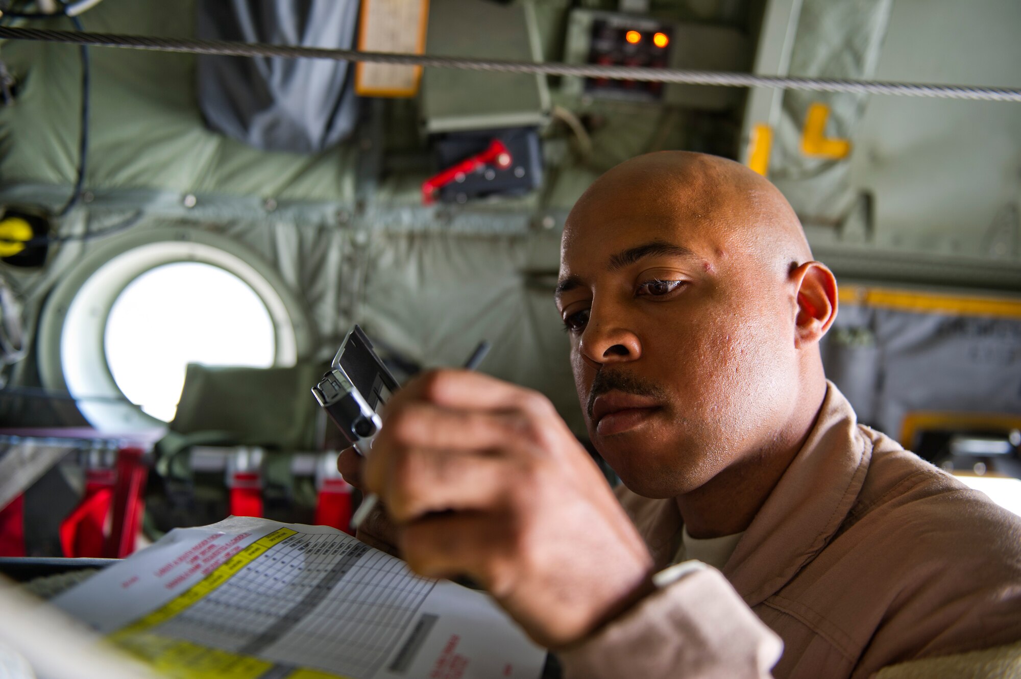 Staff Sgt. Ranon Barber, 774th Expeditionary Airlift Squadron calculates the weight of bundles of food and supplies that were loaded on a U.S. Air Force C-130 Hercules at Kandahar, Afghanistan, on Nov., 23, 2011. The bundles are going to be airdropped to Soldiers at a remote locations in eastern Afghanistan. Barber is deployed to Afghanistan from the 145th Air Wing, Air National Guard, Charlotte, N.C. (U.S. Air Force photo/Master Sgt. Jeffrey Allen)