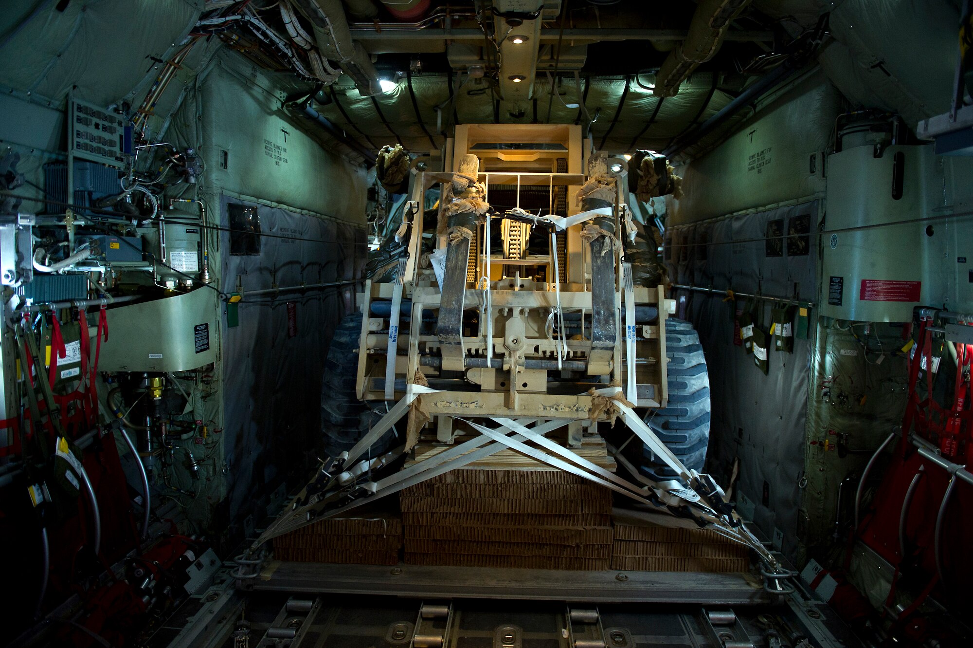 A forklift, rigged for an aerial delivery, fills the back of a U.S. Air Force C-130 Hercules moments before it is airdropped to troops at a remote area in Afghanistan on Nov 23, 2011. The C-130 is being flown by a crew from the 774th Expeditionary Airlift Squadron, Bagram Air Field, Afghanistan. The crew is deployed to Afghanistan from the 145th Air Wing, Air National Guard, Charlotte, N.C. (U.S. Air Force photo/Master Sgt. Jeffrey Allen)