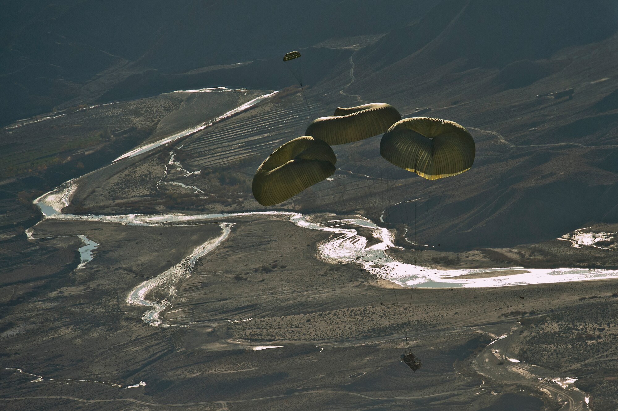 A forklift floats to the ground under parachutes after being dropped from a U.S. Air Force C-130 Hercules from the 774th Expeditionary Airlift Squadron, Bagram Air Field, Afghanistan, on Nov. 23, 2011. The forklift is being dropped to Soldiers at a remote base in eastern Afghanistan. (U.S. Air Force photo/Master Sgt. Jeffrey Allen)
