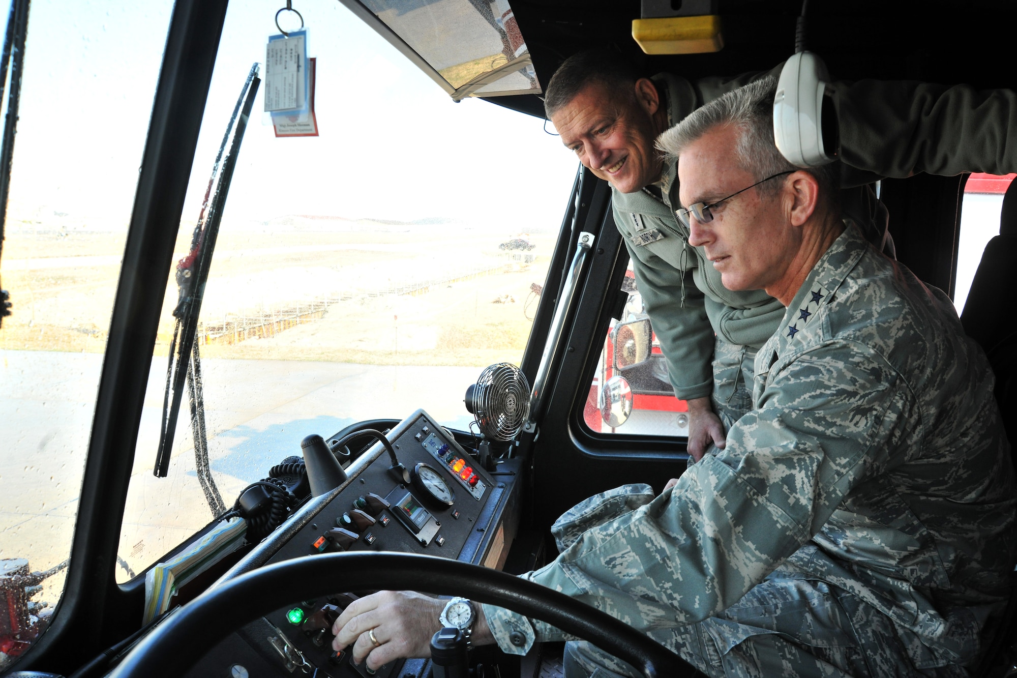 Gen. Gary North, Pacific Air Forces commander, and Lt. Gen. Paul Selva, PACAF vice commander, operate the controls inside a fire truck during their tour of Kunsan Air Base, Republic of Korea, Nov. 21. The 8th CES fire fighters were able to show their capabilities and readiness to take the fight north, if required. (U.S. Air Force photo by Senior Airman Brittany Y. Auld/Released)