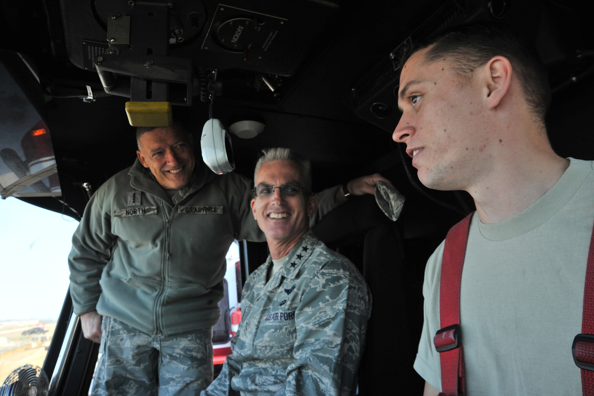 Gen. Gary North, Pacific Air Forces commander, and Lt. Gen. Paul Selva, PACAF vice commander, talk with Senior Airman Jackie Willard, 8th Civil Engineer Squadron fire fighter, inside a fire truck during their tour of Kunsan Air Base, Republic of Korea, Nov. 21. The 8th CES fire fighters were able to show their capabilities and readiness to take the fight north, if required. (U.S. Air Force photo by Senior Airman Brittany Y. Auld/Released)