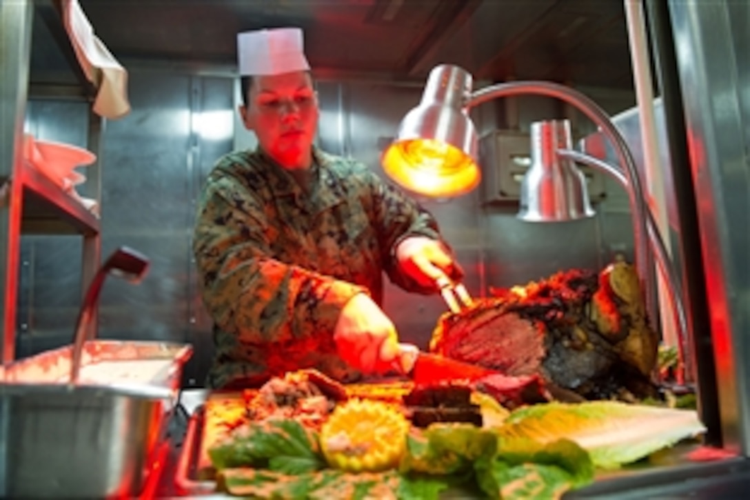 U.S. Marine Corps Gunnery Sgt. Davohn-lee H. Correa carves roast beef for a Thanksgiving celebration aboard amphibious dock landing ship USS Pearl Harbor  in the Pacific Ocean, Nov. 24, 2011.  Correa is the supply chief for Combat Logistics Battalion 11. 