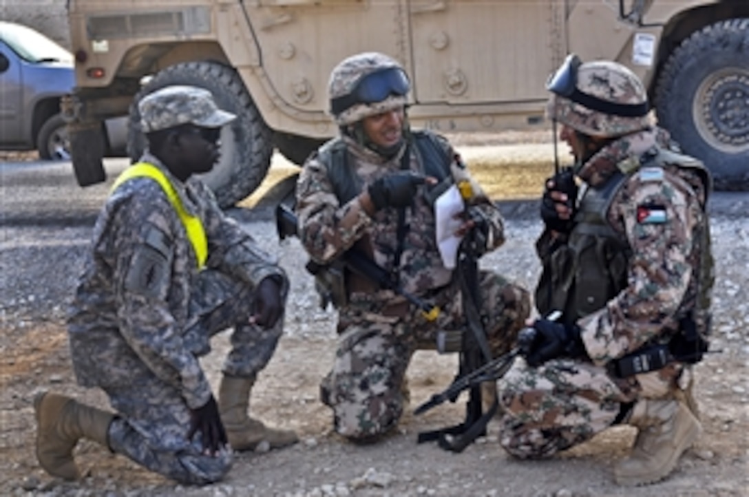 Jordanian soldiers discuss battle strategies while a U.S. soldier, left, stands by in case an interpreter is needed during a situational training exercise near Amman, Jordan, Nov. 24, 2011. The troops were taking part in Operation Flexible Saif, a joint training exercise to improve future security operations.