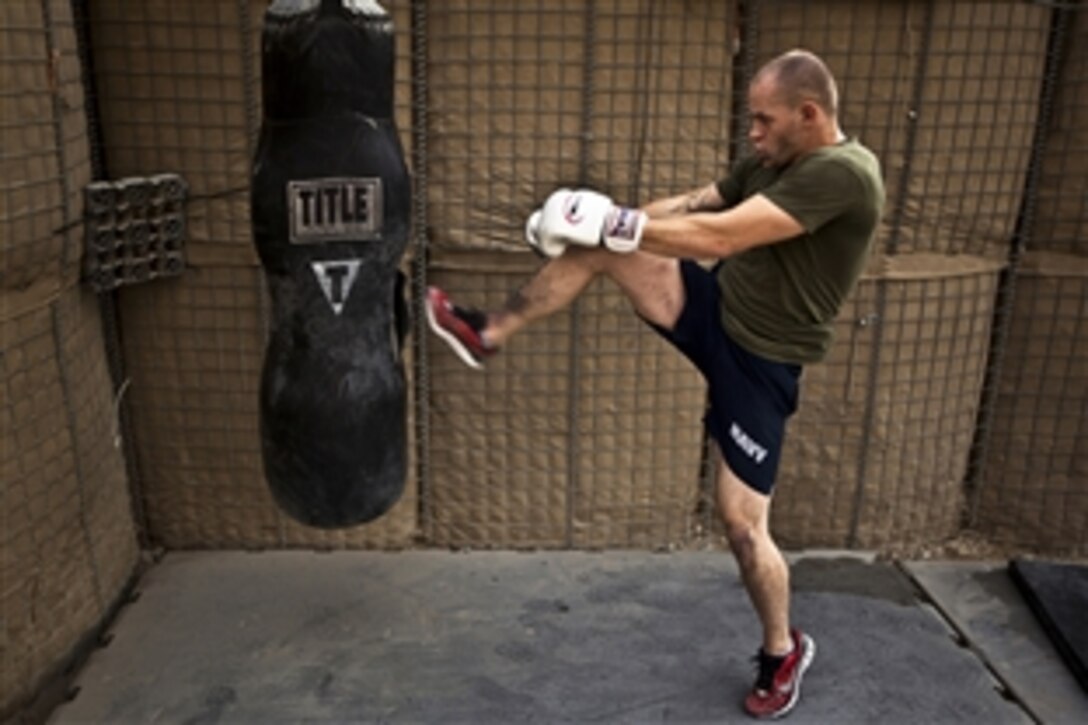 U.S. Navy Seaman Chris Mesnard practices kickboxing while training in mixed martial arts inside a makeshift combat-zone gym in the Garmsir District, Helmand Province, Afghanistan, Nov. 26, 2011. 