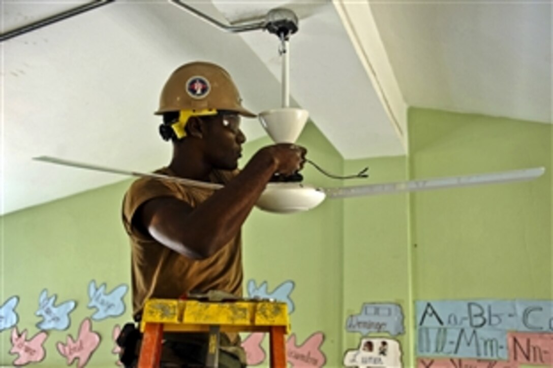 U.S. Navy Petty Officer 2nd Class Tyrif Wells installs a fan in a classroom at Rafaela Santaella Basic School in Santo Domingo, Dominican Republic, Nov. 24, 2011. Wells is an equipment operator assigned to Navy Mobile Construction Battalion 23, which conducted a three-week project at the school as part of an annual deployment of U.S. ships to the U.S. Southern Command's area of responsibility in the Caribbean and Latin America.