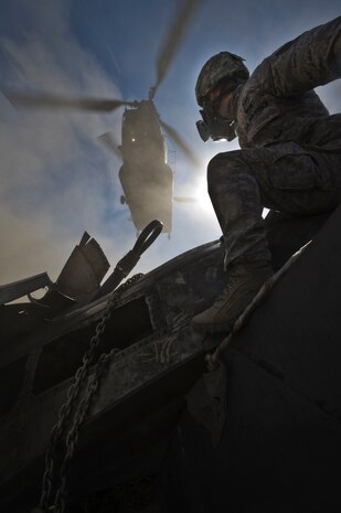 U.S. Air Force Staff Sgt. Ian Zerby, 820th RED HORSE Squadron airborne flight member, prepares to rig a connex box for a sling-load as a CH-47 Chinook from the Army National Guard, Stockton, Calif., hovers overhead during a peacetime operation Nov. 9, 2011, in the Nevada Test and Training Range. The sling load training and air assault certification of 820th RHS airborne flight Airmen proved crucial in the success of the quick-response operation. (U.S. Air Force photo by Airman 1st Class Daniel Hughes/Released)