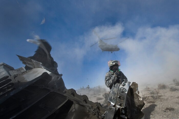 A U.S. Air Force Airman, 820th RED HORSE Squadron airborne flight, prepares to rig a connex box for a sling-load as a CH-47 Chinook from the Army National Guard, Stockton, Calif., hovers overhead during a peacetime operation Nov. 9, 2011, in the Nevada Test and Training Range. The sling load training and air assault certification of 820th RHS airborne flight Airmen proved crucial in the success of the quick-response operation. (U.S. Air Force photo by Airman 1st Class Daniel Hughes/Released)
