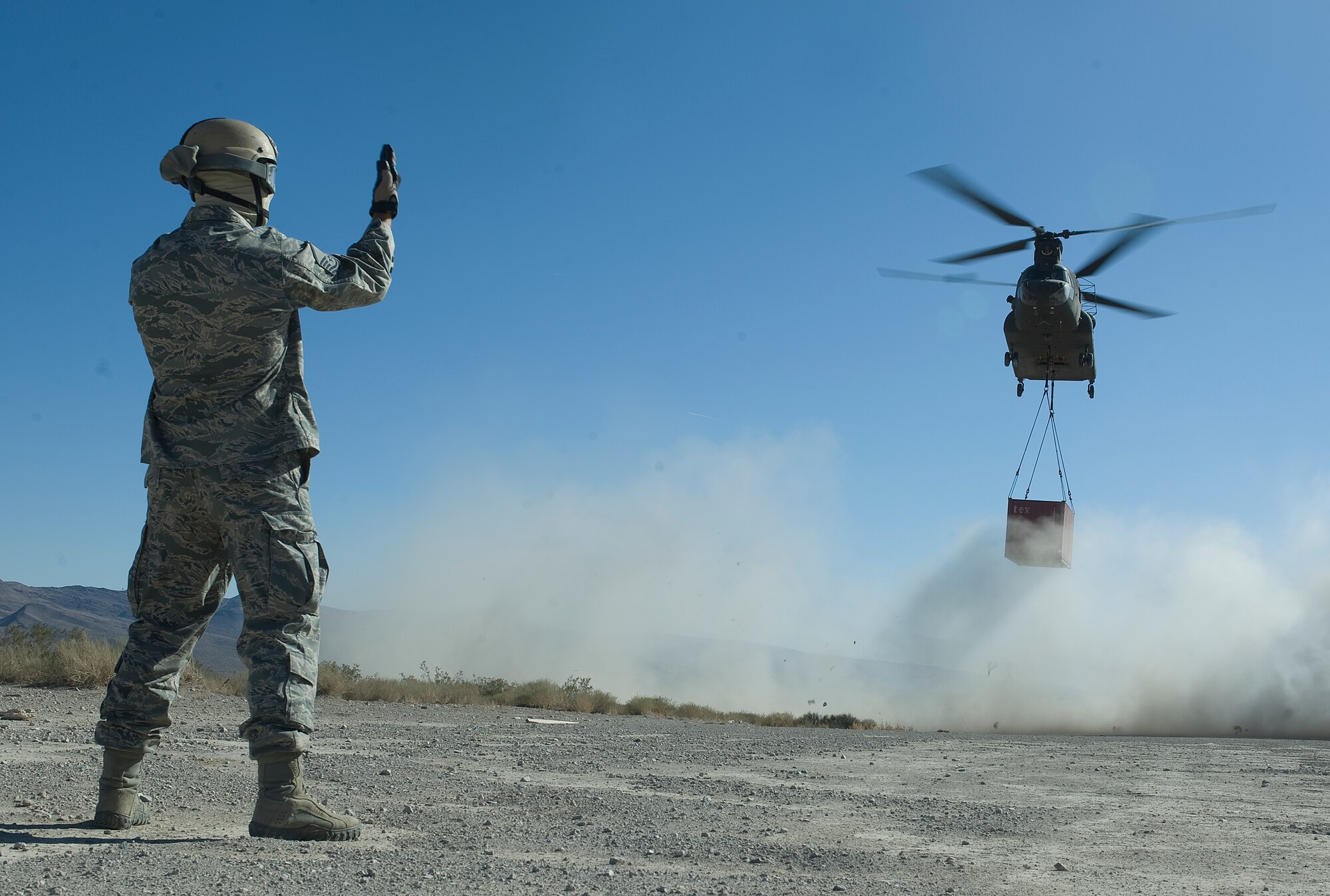 U.S. Air Force Master Sgt. Guenther Bogensperger, 820th RED HORSE airborne flight airborne water and fuels systems maintenance superintendent, guides in a CH-47 Chinook from the Army National Guard, Stockton, Calif., to a designated drop site during a peacetime operation Nov. 9, 2011, in the Nevada Test and Training Range.The sling load training and air assault certification of 820th RHS airborne flight Airmen proved crucial in the success of the quick-response operation.
(U.S. Air Force photo by Staff Sgt. Christopher Hubenthal/Released)