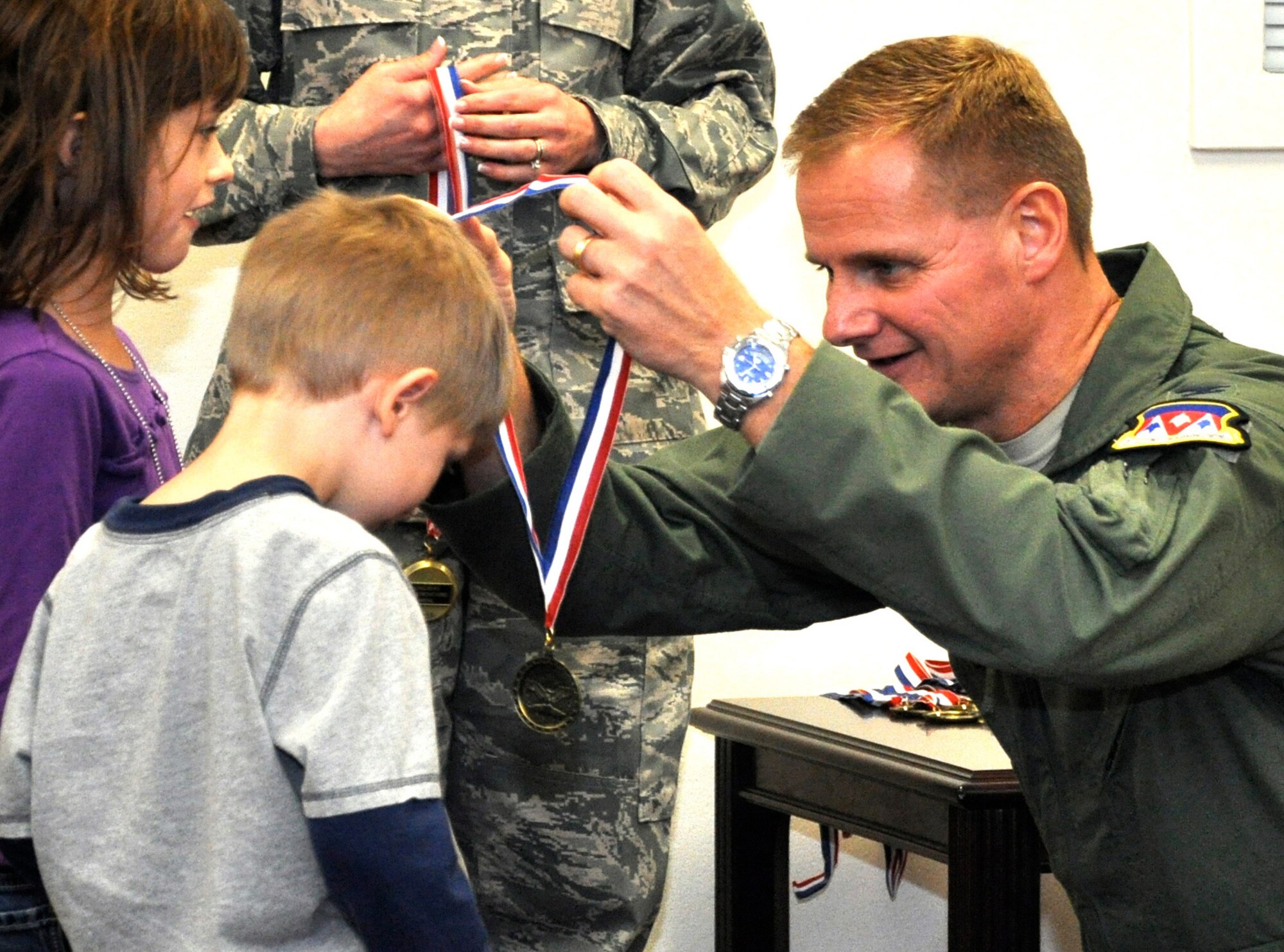 Col. Russ Mack, commander of the 71st Flying Training Wing at Vance Air Force Base, Okla., awards the child of a deployed Vance Airman a Home-Front-Hero medal at the Month of the Military Family celebration held Nov. 18 in the Airman & Family Readiness Center. More than 140 folks attended the celebration, which included contests for pie and ice cream eating and hula-hoop twirling. The Month of the Military Family recognizes what families of military members go through when their loved ones are away from home serving their country. (U.S. Air Force photo/ Airman 1st Class Frank John Casciotta)