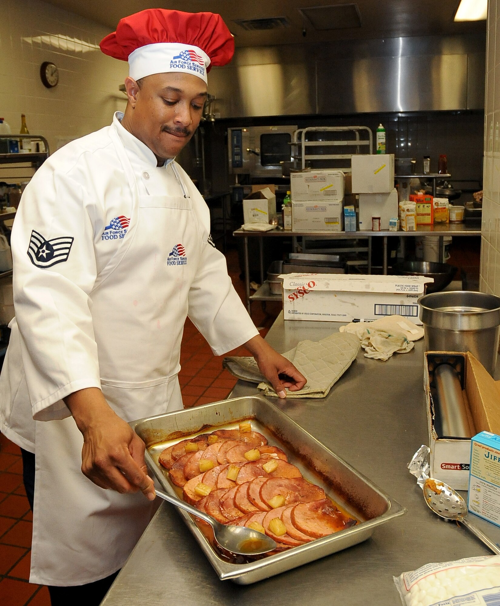 A 2nd Force Support Squadron member prepares ham to be served at the Consolidated Club on Barksdale Air Force Base, La., Nov. 24. More than 50 Barksdale families dined together during a Thanksgiving meal served by base leadership volunteers. Team Barksdale families enjoyed turkey, ham, several side dishes and numerous desserts during the banquet. (U.S. Air Force photo/Senior Airman Amber Ashcraft)(RELEASED)