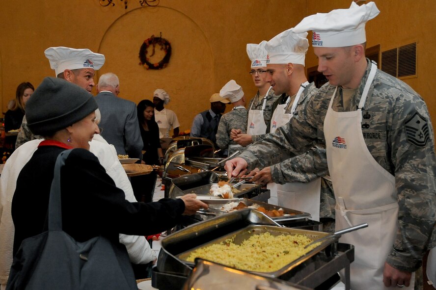 Master Sgt. Anthony Grubb, 2nd Comptroller Squadron first sergeant, serves sweet potatoes to waiting patrons at the Consolidated Club on Barksdale Air Force Base, La., Nov. 24. More than 20 base leaders volunteered to serve a large Thanksgiving meal to Barksdale families and retirees. (U.S. Air Force photo/Senior Airman Amber Ashcraft)(RELEASED)