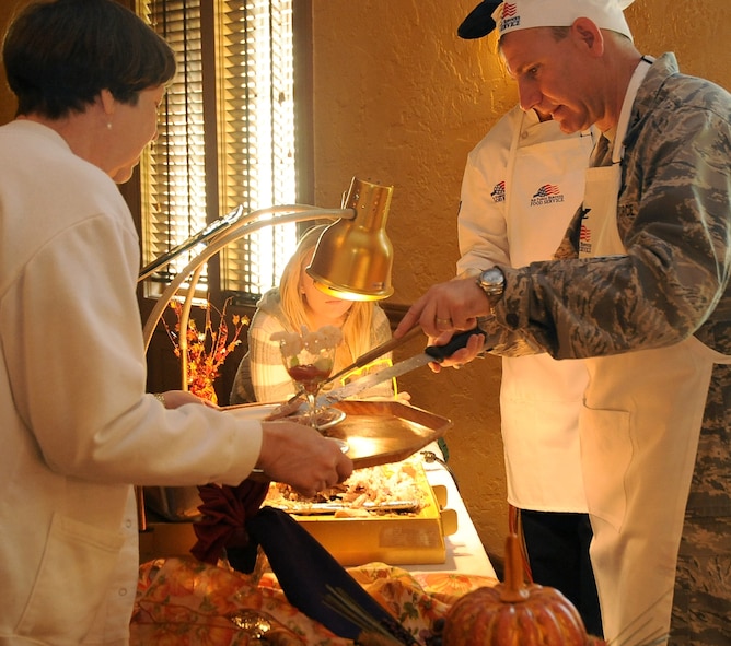 Col. Tim Fay, 2nd Bomb Wing commander, serves turkey to waiting patrons at the Consolidated Club on Barksdale Air Force Base, La., Nov. 24. More than 20 base leaders served a large Thanksgiving meal to Barksdale Airmen, retirees and family members. (U.S. Air Force photo/Senior Airman Amber Ashcraft)(RELEASED)