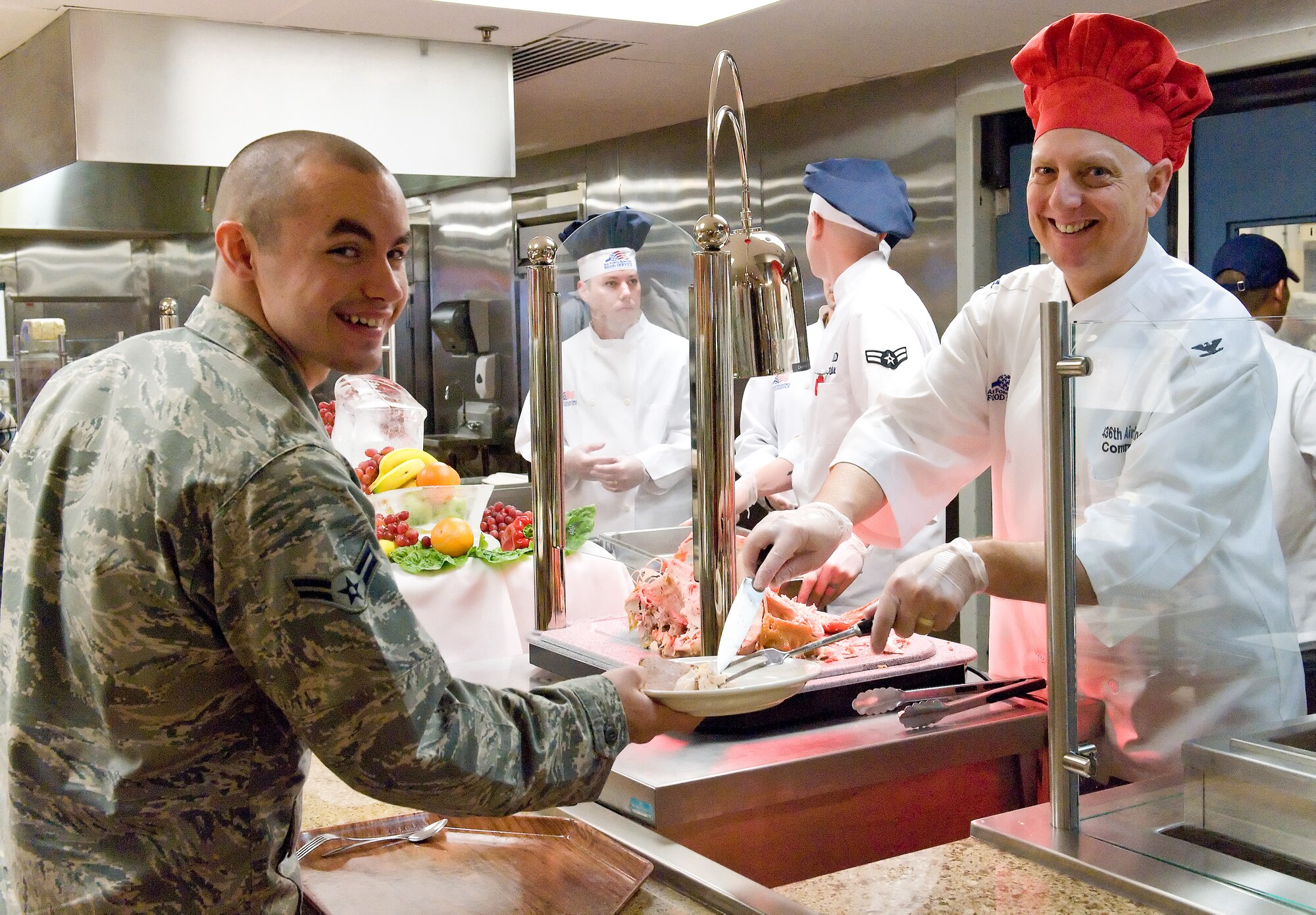 Col. Mark Camerer, commander of the 436th Airlift Wing, serves Thanksgiving turkey to Airman 1st Class Brandon Dale Nov. 24, 2011, at the Dover Air Force Base, Del., Dining Facility. Commanders, chief master sergeants and first sergeants served active-duty military, retirees and dependents Thanksgiving Day meals. (U.S. Air Force photo/Roland Balik)