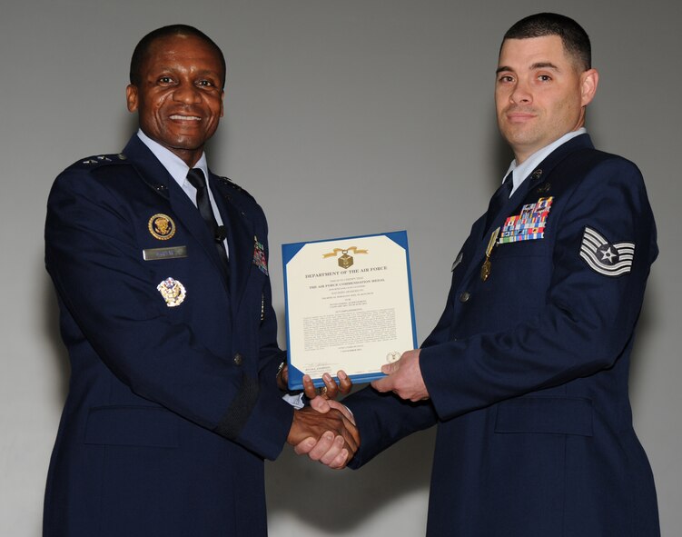 Air Force District of Washington Commander Maj. Gen. Darren McDew presents the Air Force Commendation Medal to Tech. Sgt. Joel Ketchum, AFDW legal NCOIC military justice, at the Nov. 18 commander’s call on Joint Base Andrews, Md. McDew recognized seven Airmen in AFDW for superior service and support. (U.S. Air Force photo by Staff Sgt. Christopher Ruano)