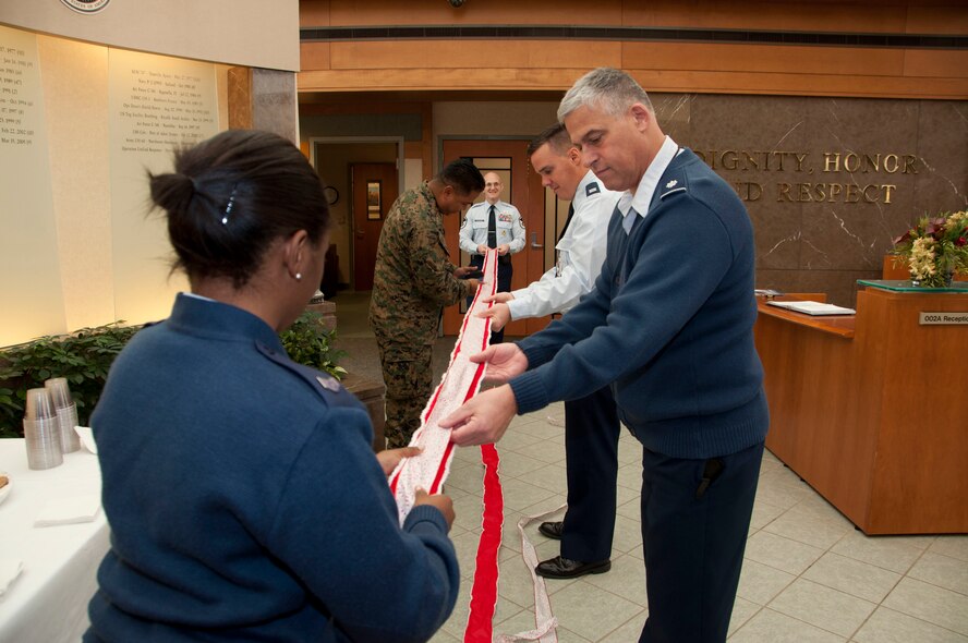 Personnel at the Charles C. Carson Center for Mortuary Affairs straighten out a ribbon for the Christmas tree in the atrium of the facility. People gathered to decorate the tree Nov. 29, 2011 in preparation for the Tree Lighting ceremony scheduled for Dec. 1, 2011. (U.S. Air Force photo/Tech. Sgt. Marvin Moore)