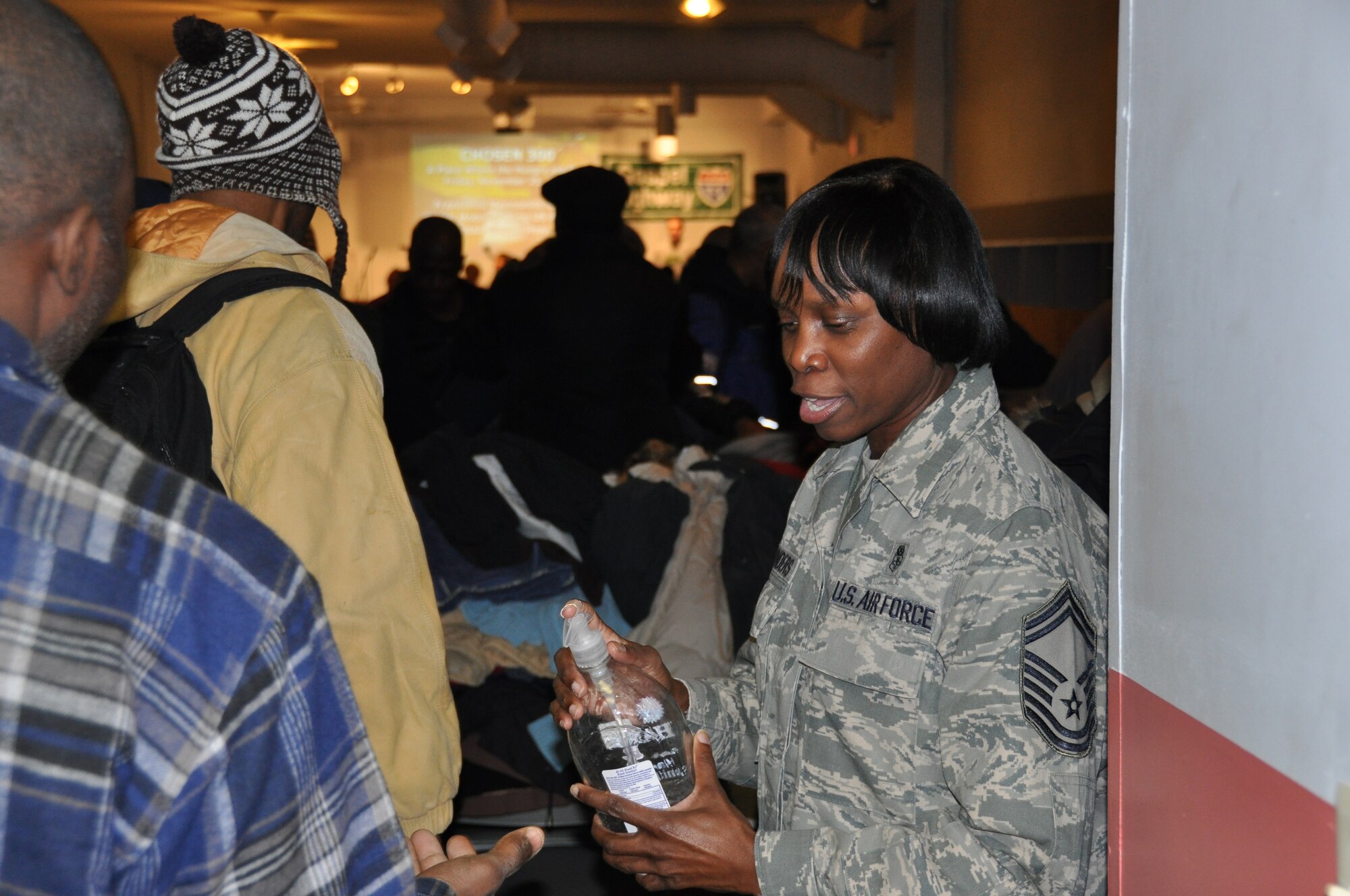 JOINT BASE MCGUIRE-DIX-LAKEHURST, N.J. -  Senior Master Sgt. Donna Waters, a volunteer from the 514th Air Mobility Wing, offers hand sanitizer to more than 200 homeless dinner guests of Chosen 300 Ministries Inc., located in Philadlelphia, Pa., Nov 26. Numerous Air Force Reserve volunteers from Joint Base McGuire-Dix-Lakehurst, N.J., spent their Thanksgiving Holiday giving back to others in the local community. (U.S. Air Force photo/Master Sgt. Donna T. Jeffries)