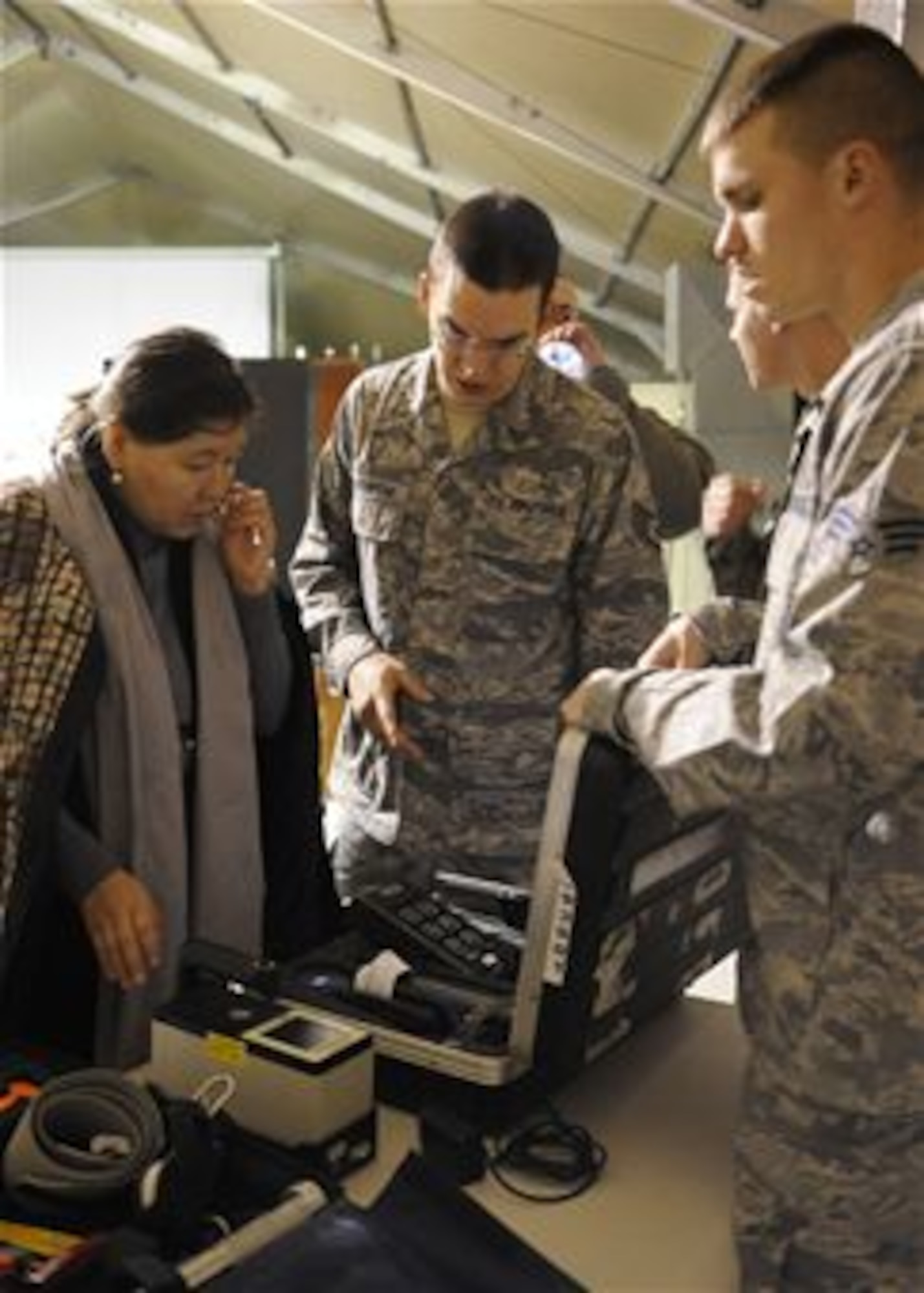 Staff Sgt. Igor Pogrebnyak (middle) translates Senior Airman Nate Gunty’s explanation of a ADM-300 radiological detection machine to Cholpon Chekirova during an information exchange at the Transit Center at Manas, Kyrgyzstan, Nov. 22, 2011. Chekirova is a member of the Kyrgyz Ministry of Emergency Services. Pogrebnyak is a Theater Security Cooperation linguist deployed from Creech Air Force Base, Nev. Gunty is a 376th Expeditionary Civil Engineer Squadron chemical, biological, radiological, nuclear and high-yield explosives response specialist deployed from Vandenberg Air Force Base, Calif. (U.S. Air Force photo/Tech. Sgt. Tammie Moore)
