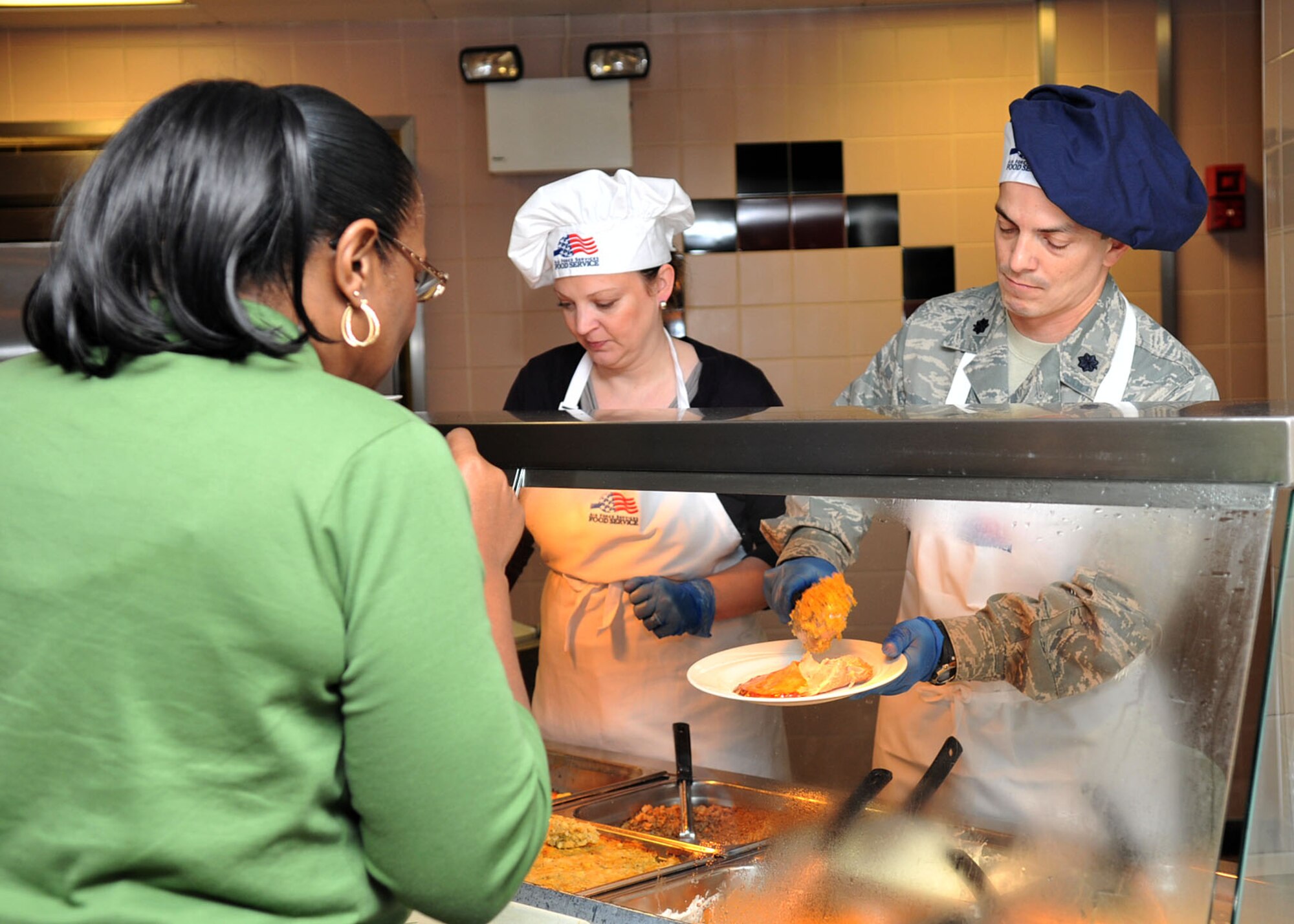 RAF MILDENHALL, England - Lt. Col. Bob Gerleman, 100th Air Refueling Wing Staff Judge Advocate (right), dishes a plate of food during the Gateway Dining Facility’s Thanksgiving meal here Nov. 24, 2011. Commanders and their spouses volunteered to serve Airmen and their families, as a way to show appreciation for their hard work and dedication. (U.S. Air Force photo/Senior Airman Jerilyn Quintanilla)
