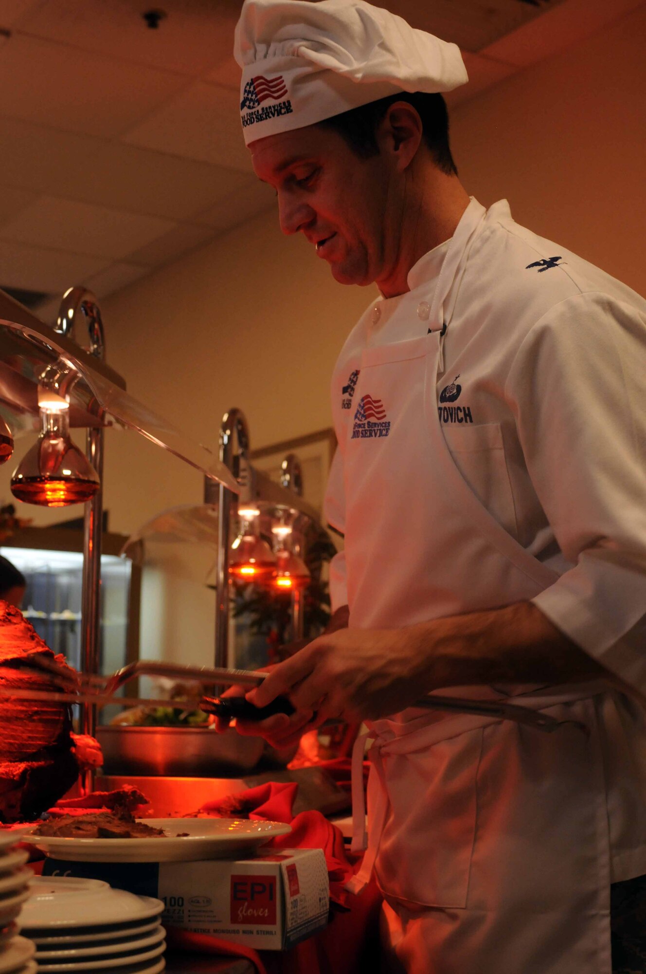Col. Dean Ostovich, 31st Fighter Wing vice commander, slices a turkey Nov. 24 at La Dolce Vita Dining Facility on Aviano Air Base, Italy. The dining facility staff prepared a holiday meal while base leadership volunteered to serve Airmen and their families. (U.S. Air Force photo/ Airman 1st Class Jenay Randolph)