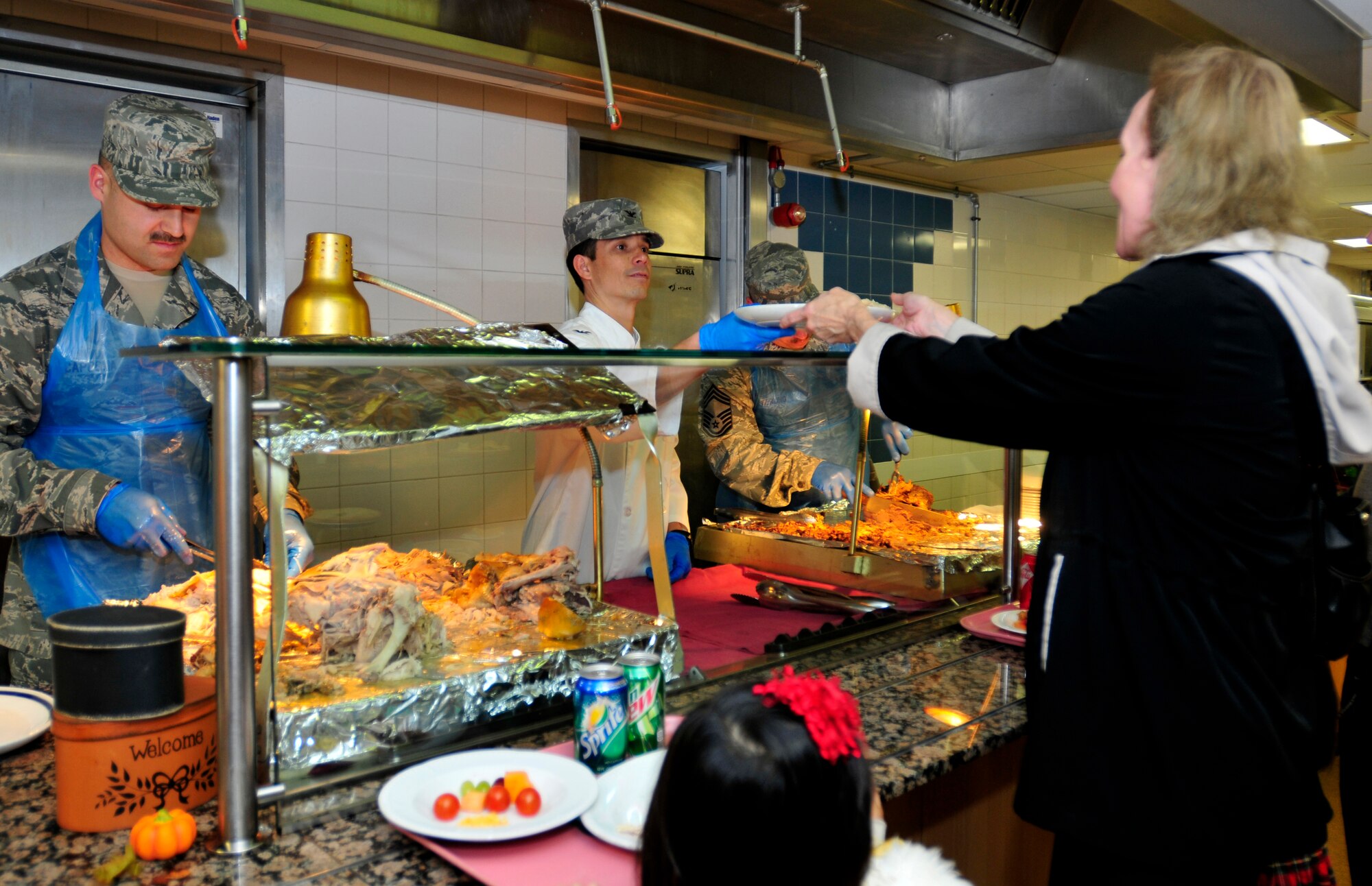 ROYAL AIR FORCE LAKENHEATH, England - Col. John Quintas, 48th Fighter Wing commander, and other base leadership officials serve up Thanksgiving meals at the Knight's Inn Dining Facility, Nov. 24, 2011. Each year, base leadership officials volunteer their time to serve Thanksgiving meals to Airmen, civilians and families. (U.S. Air Force photo by Senior Airman Tiffany M. Deuel)