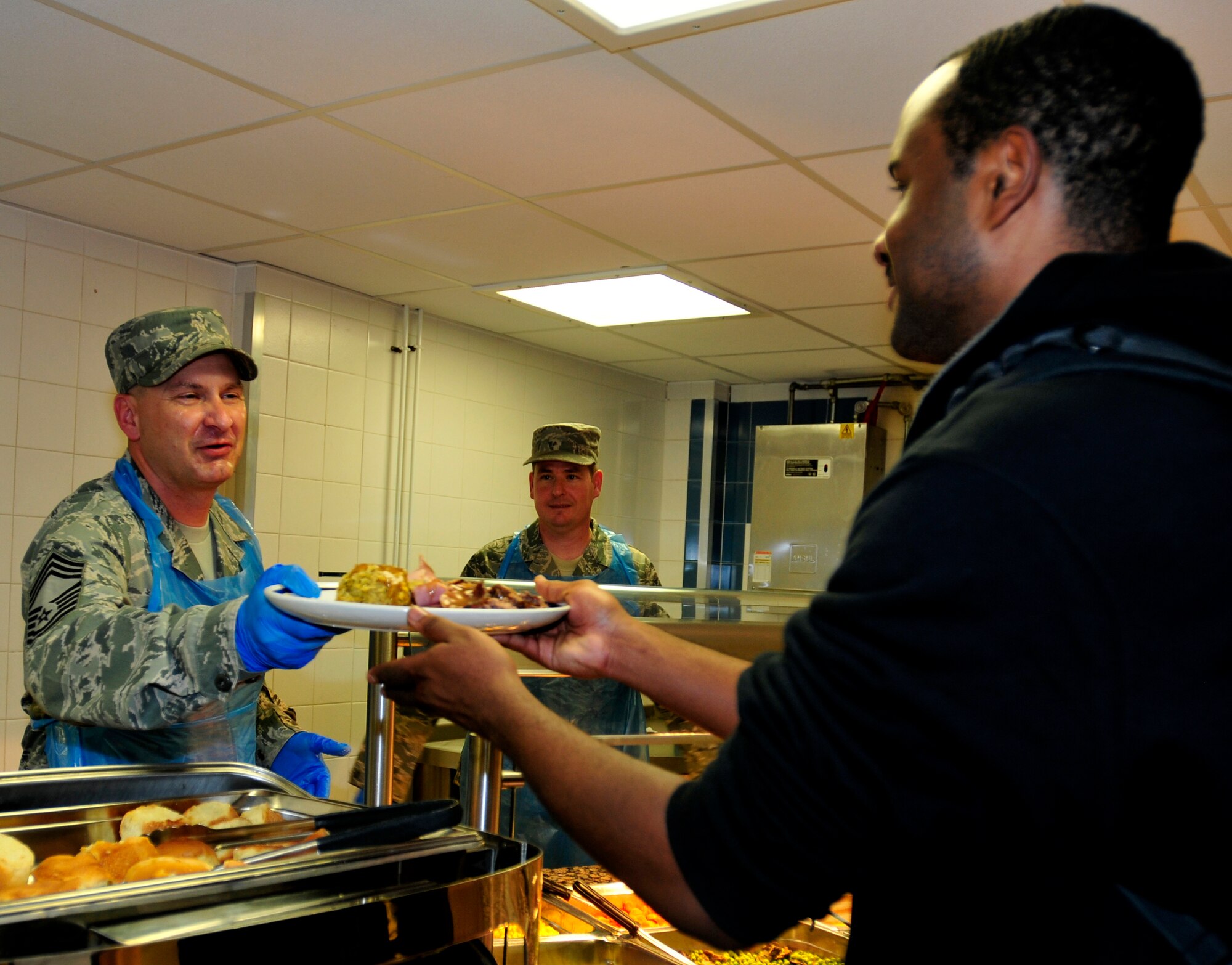 ROYAL AIR FORCE LAKENHEATH, England - Chief Master Sgt. John Mazza 48th Mission Support Group command chief, serves up a Thanksgiving meal to Airman Anthony Brooks, 48th Medical Support Squadron histology technician,  at the Knight's Inn Dining Facility, Nov. 24, 2011. Each year, base leadership officials volunteer their time to serve Thanksgiving meals to Airmen, civilians and families. (U.S. Air Force photo by Senior Airman Tiffany M. Deuel)