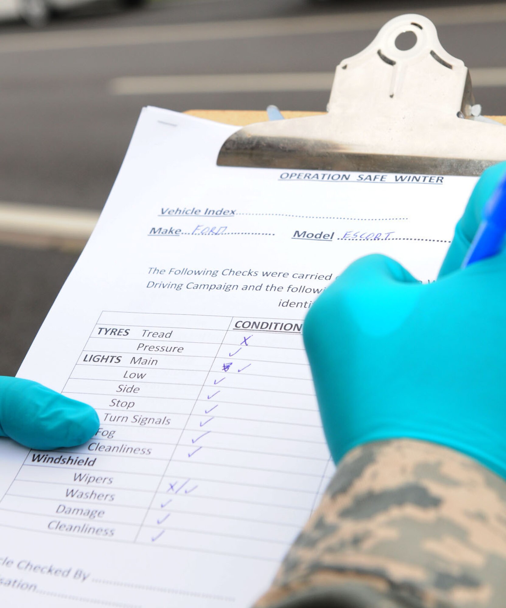 RAF MILDENHALL, England -- Airman 1st Class Owen Gill, 100th Logistics Readiness Squadron Vehicle Maintenance, marks off items on a winter safety checklist for a vehicle which was randomly stopped and offered an inspection here Nov. 22, 2011. Airmen from vehicle maintenance and the 100th Air Refueling Wing Safety office conducted inspections in conjunction with the Ministry of Defence Police at RAF Mildenhall and RAF Lakenheath, as part of Road Safety Week. Vehicles were randomly stopped, information leaflets were handed out, and the vehicle maintenance and safety personnel used checklists to inspect items including tires, wipers and lights. Master Sgt. Dominic Cilia, 100th ARW Ground Safety manager, said they educated a lot of people on where fog lights were situated. "Many people didn't know, and most were unaware of the bad condition of their vehicle," he said. "We found several badly worn tires and wiper blades, and some vehicles with lights not working. All these are safety issues which can cause mishaps and accidents, especially in bad weather. If we can prevent even one accident by doing these checks, then we're doing our job." (U.S. Air Force photo/Karen Abeyasekere)