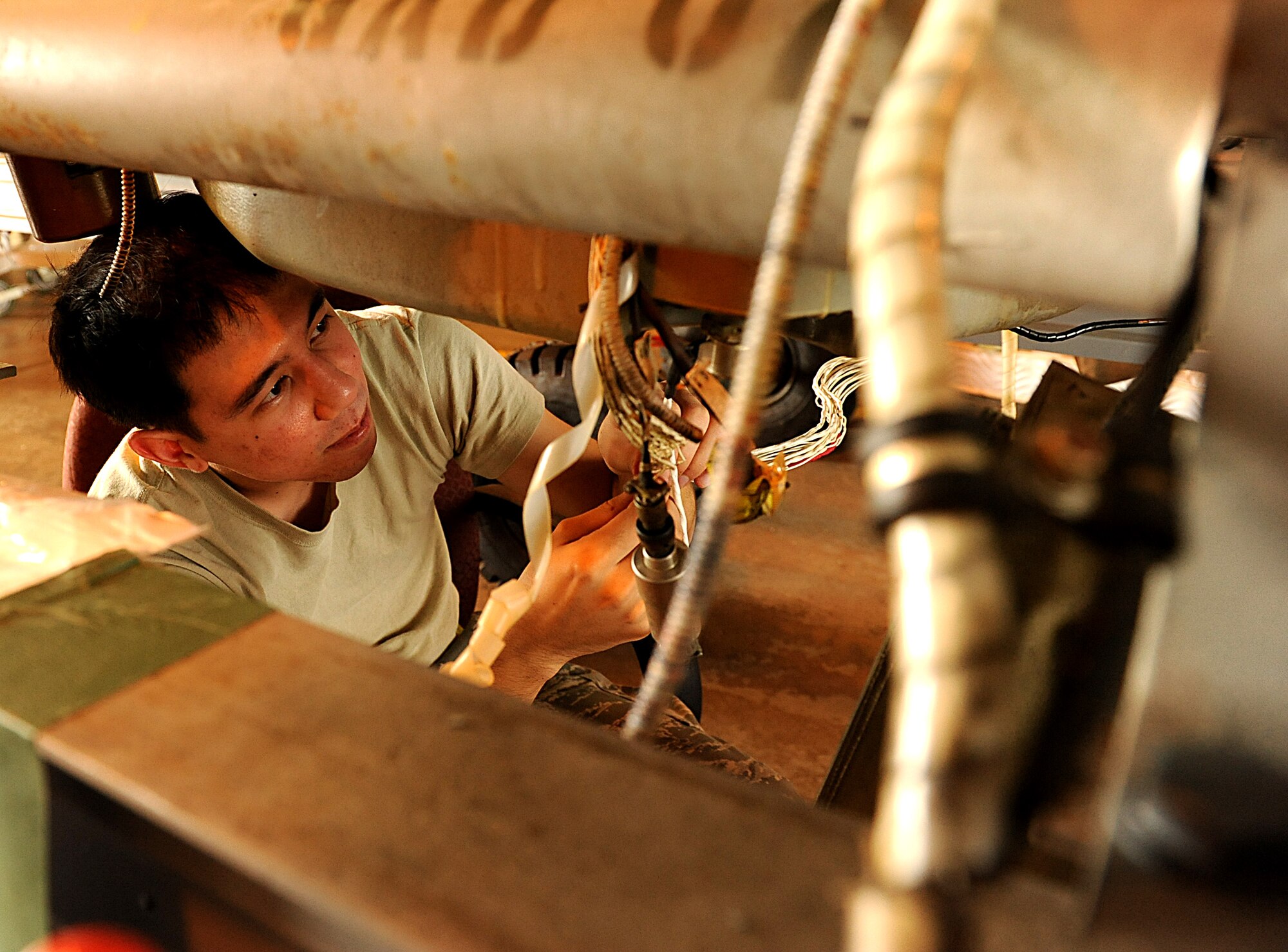 U.S. Air Force Airman 1st Class Stephen Blackhall, 718th Aircraft Maintenance Squadron electrical environmentalist, cleans and inspects wires for corrosion under the gearbox of an U.S. Air Force HH-60G Pave Hawk helicopter on Kadena Air Base, Japan, Nov. 2, 2011. The 718th Aircraft Maintenance Squadron recently earned the Air Force Maintenance Effectiveness Award for effective management of its resources and its contributions to the mission. (U.S. Air Force photo by Airman 1st Class Justin Veazie/Released)