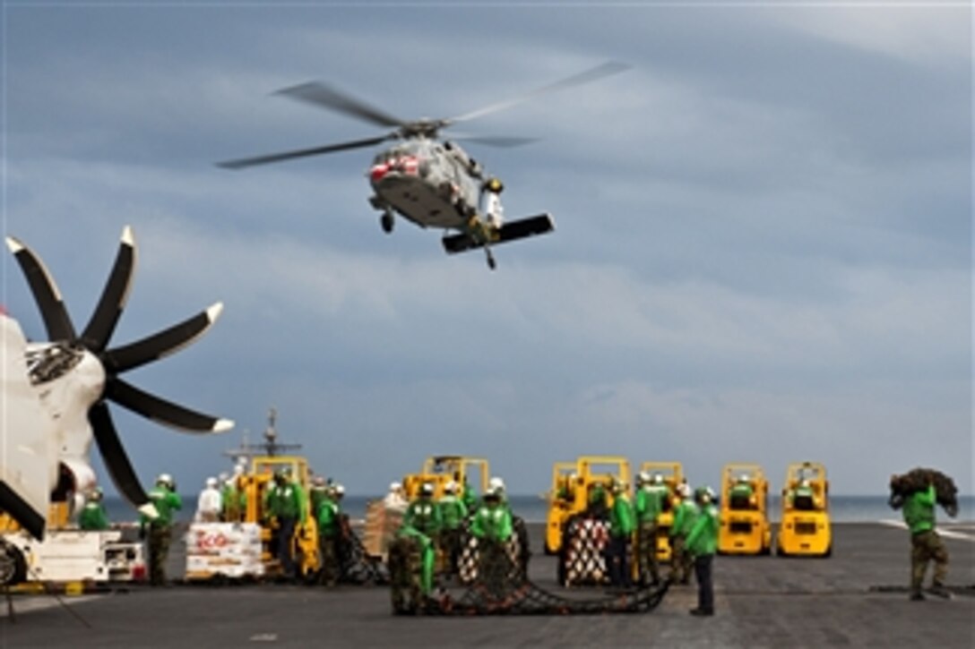 U.S. Navy sailors aboard the aircraft carrier USS John C. Stennis prepare cargo nets during a replenishment at sea in the Persian Gulf on Nov. 22, 2011.  The John C. Stennis deployed to the U.S. 5th Fleet area of responsibility to conduct maritime security operations and support missions as part of operations Enduring Freedom and New Dawn.  