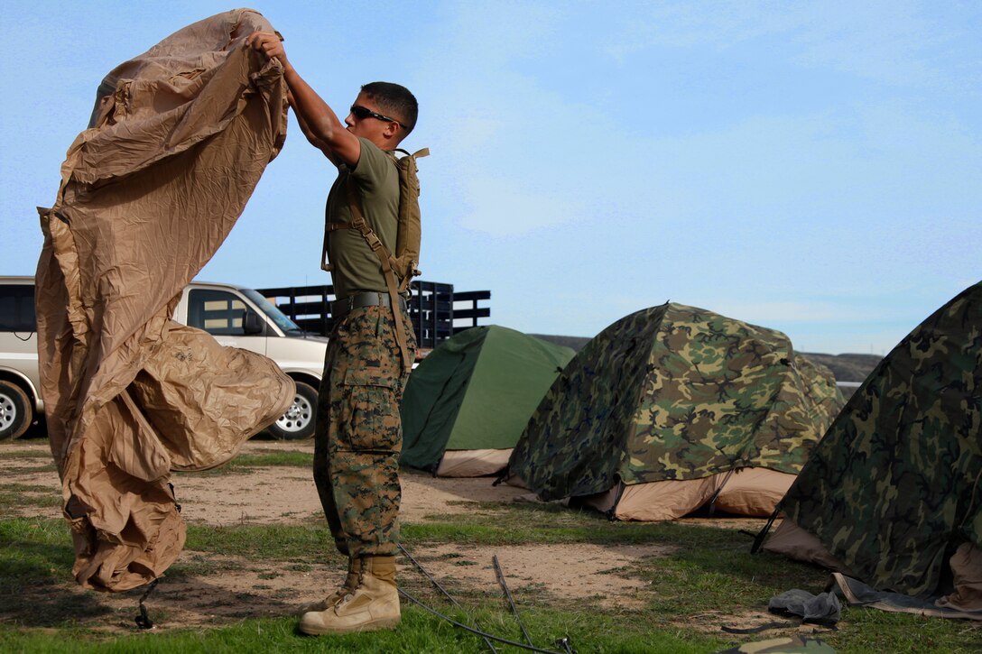 Lance Cpl. Richard A. Hernandez, data clerk, 15th Marine Expeditionary Unit Command Element, helps Marines set up their tents during Command Post Exercise II at Camp Pendleton, Calif, Nov. 28. Command Post Exercise II focused on the unit’s ability to stand up an entire Command Operations Center quickly in the event the MEU is called to shore. Although the exercise included training for this specific event, CPEX II brought the Marines and sailors together by encouraging them to work as a team and build camaraderie among each other. Hernandez, 20, is from Temecula, Calif. (U.S. Marine Corps photo by Cpl. John Robbart III)