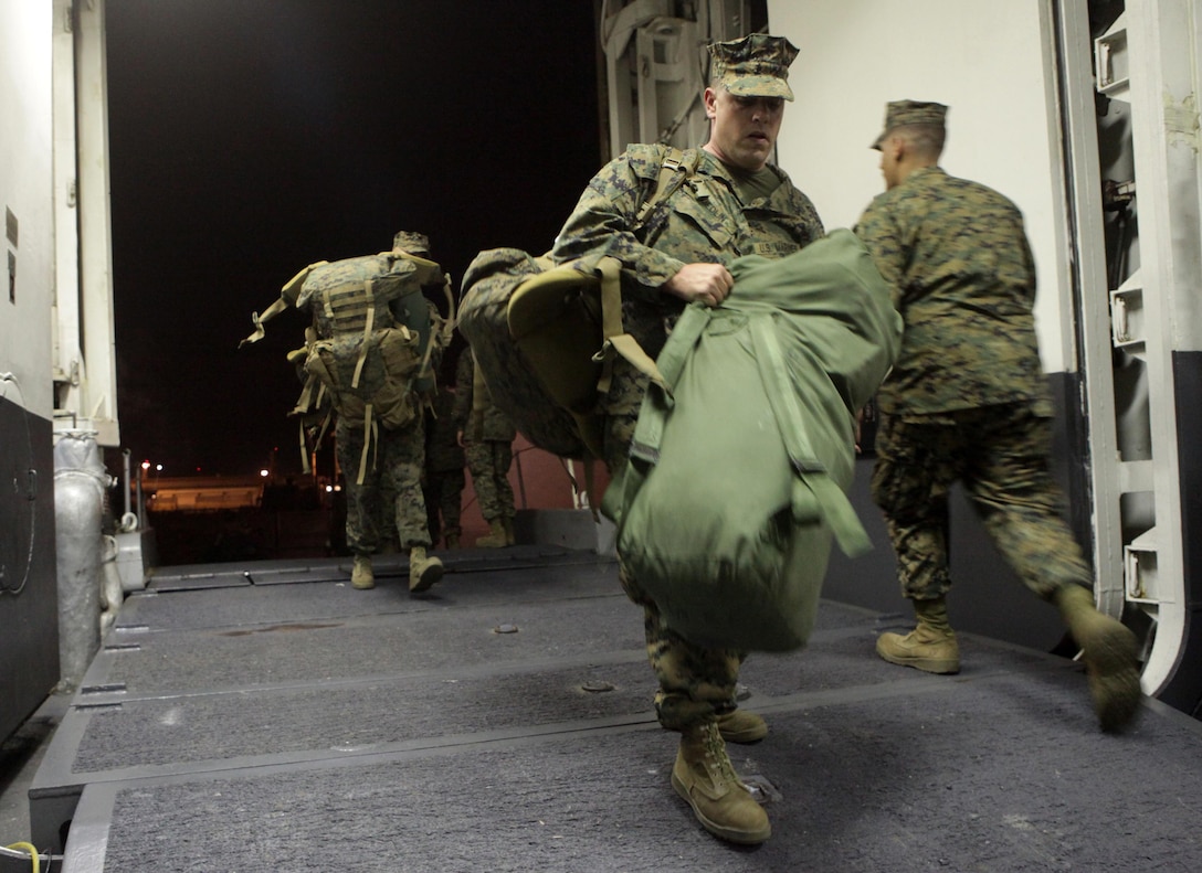 Marines and Sailors of the 24th Marine Expeditionary Unit embark on the Navy’s Amphibious Assault Ship, the USS Iwo Jima (LHD 7) docked at Naval Base Norfolk, Va. Nov. 28, prior to departing for Composite Unit Training Exercise (COMPTUEX). The exercise is scheduled to take place Nov. 28 to Dec. 21 to develop cohesion between the 24th Marine Expeditionary Unit and Amphibious Squadron 8 (PHIBRON-8) in conducting amphibious operations, crisis response, and limited contingency operations while operating from the sea.