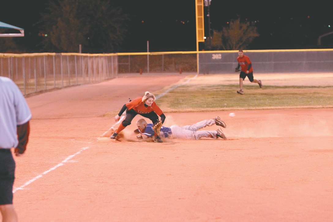 Chicks & Sticks third baseman Jeanette Hogan reaches for the ball, hoping to tag an out during the Commanding General’s Intramural Co-Ed Softball League after the championship game at Felix Field Nov. 29, 2011.