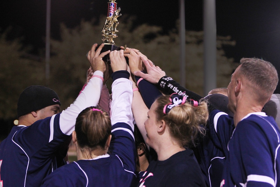 OutKasts, the defending champions, celebrate their victory against Chicks & Sticks for their second year as the top team in the Commanding General’s Intramural Co-Ed Softball League after the championship game at Felix Field Nov. 29, 2011