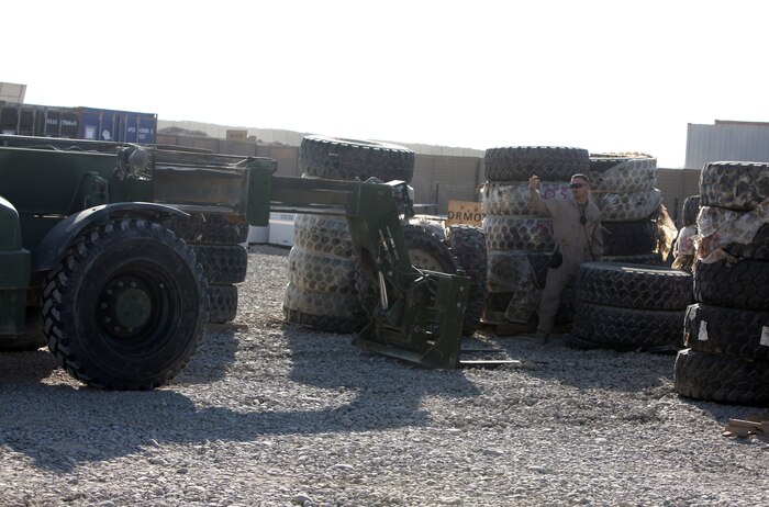 A Marine with the sort lot aboard Camp Leatherneck, Afghanistan, guides a forklift operator Nov. 29, as he inventories several tires designated as excess during Operation Clean Sweep. The purpose of the operation is to effectively and efficiently plan for how to retrograde all Marine equipment and personnel from Afghanistan. (U.S. Marine Corps Photo by 2nd Lt. James F. Stenger)