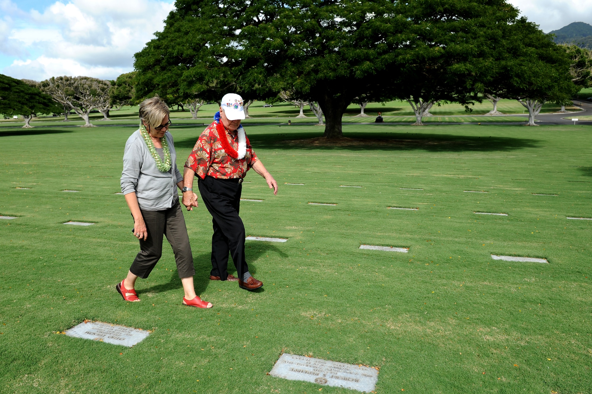 Durward Swanson, Dec. 7, 1941, Hickam Field survivor, and his cousin Cass Gannaway, walk along the headstones at the National Memorial Cemetery of the Pacific, or Punchbowl National Cemetery, Nov. 22 during his visit to Hawaii. Swanson visited the base where 70 years ago he survived the sudden attack by the Japanese on Dec. 7, 1941. (U.S. Air Force photo by Staff Sgt. Mike Meares)