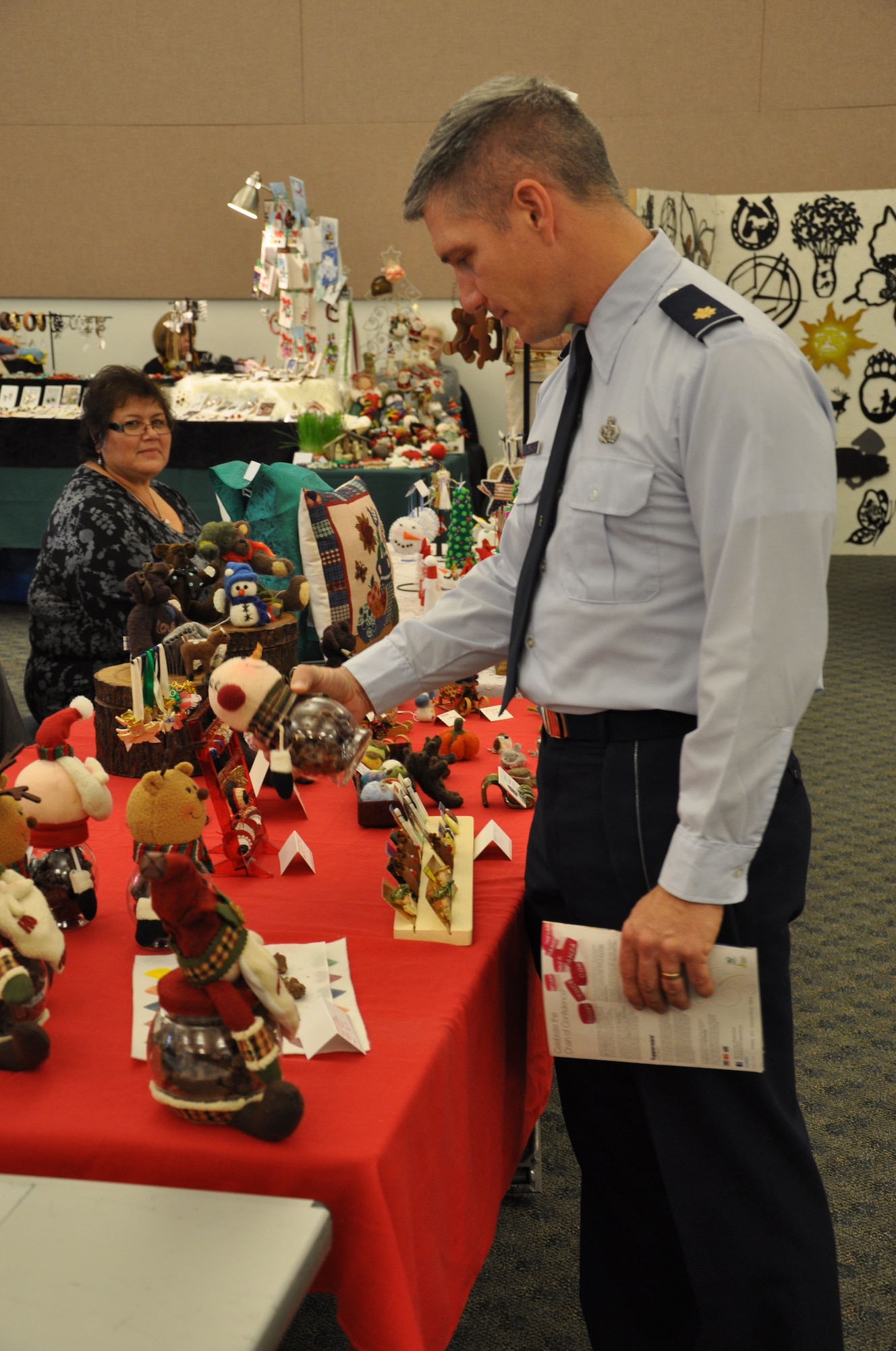 Maj. Chris Pewterbaugh, 7th Space Warning Squadron engineering specialist, browses through some holiday gifts while attending the Holiday Bazaar at the Beale Air force Base Calif., Community Activity Center Nov. 28, 2011. The Bazaar hosted more than 30 different holiday vendors. (U.S. Air Force photo by Staff Sgt. Robert M. Trujillo/Released)